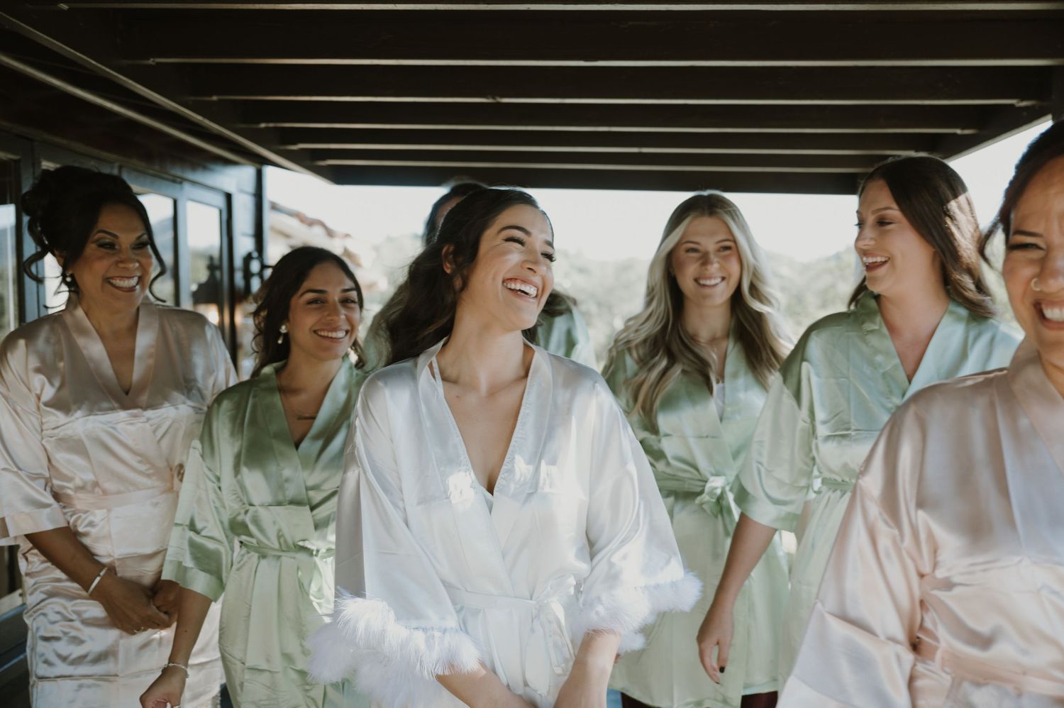 A candid moment of laughter shared among bridesmaids in matching robes.
