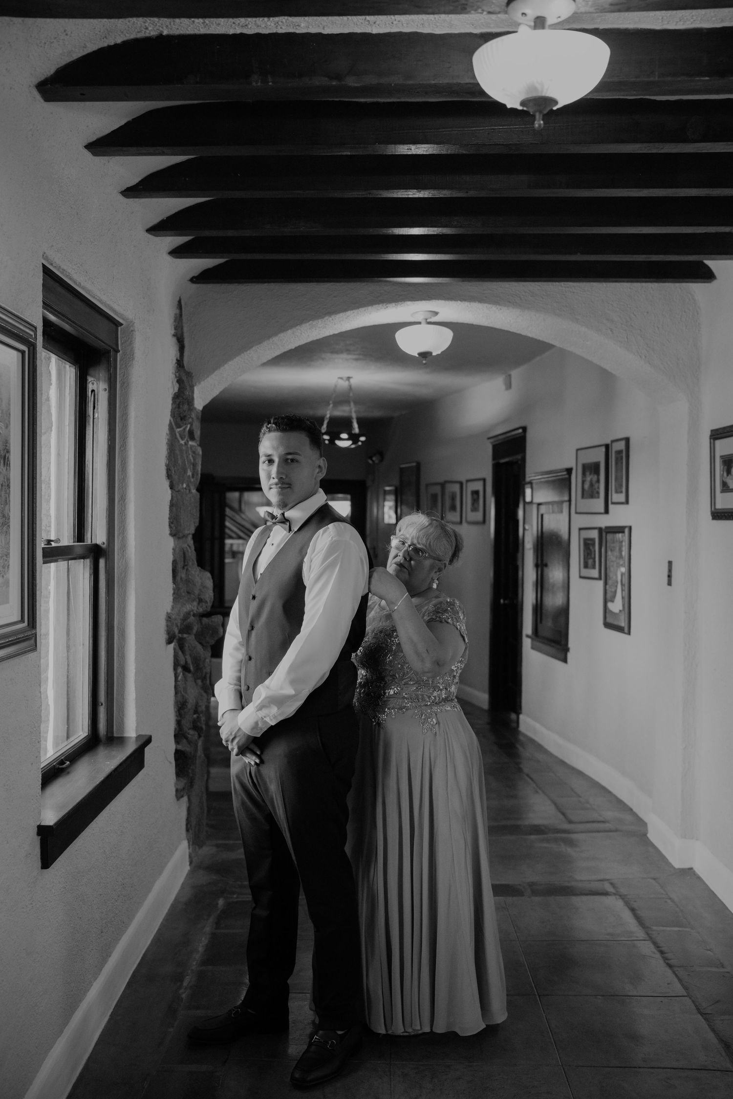 Long hallway with exposed wooden beams and vintage decor in black and white.