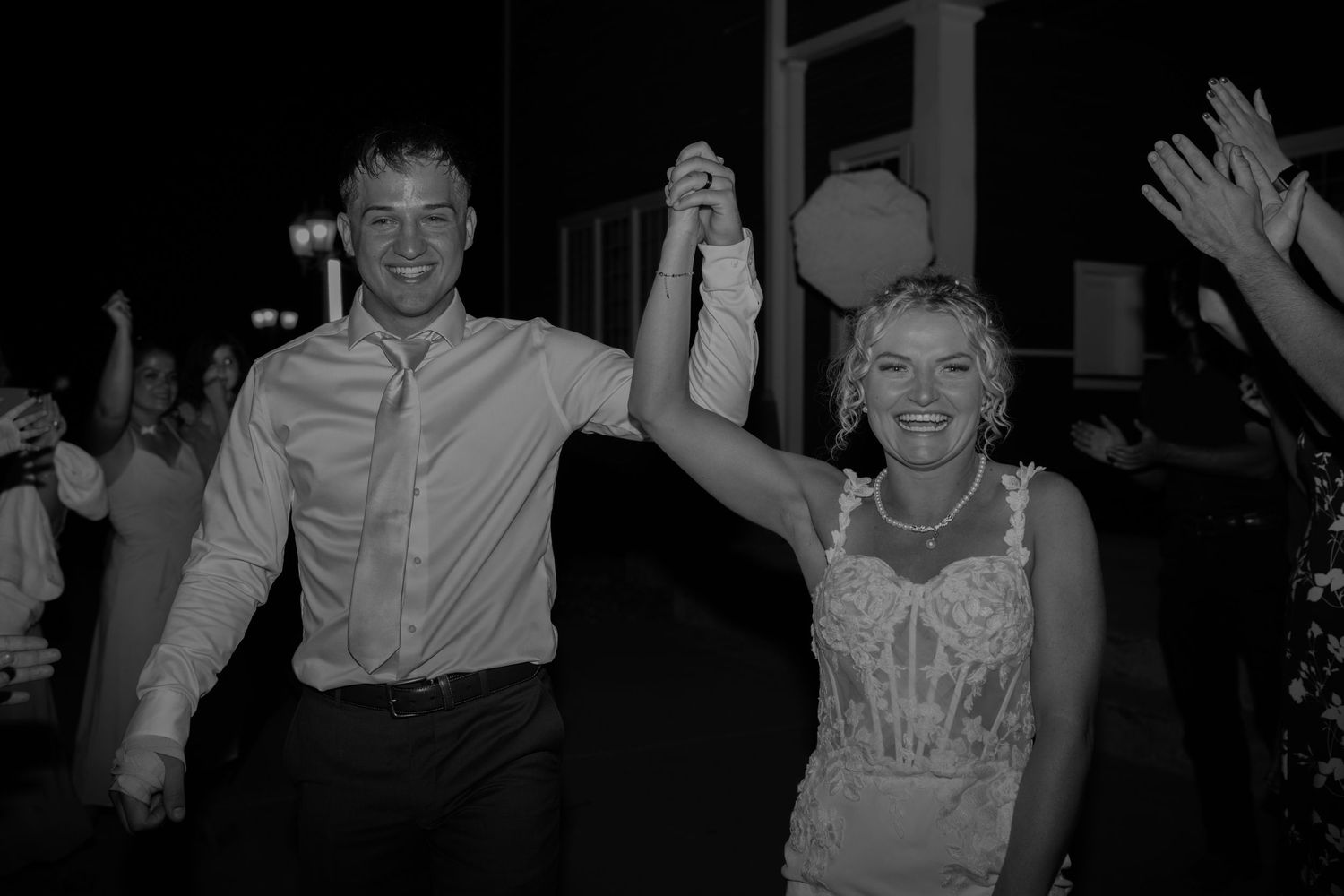 Wedding party celebrates with joyful dancing during an evening reception.
