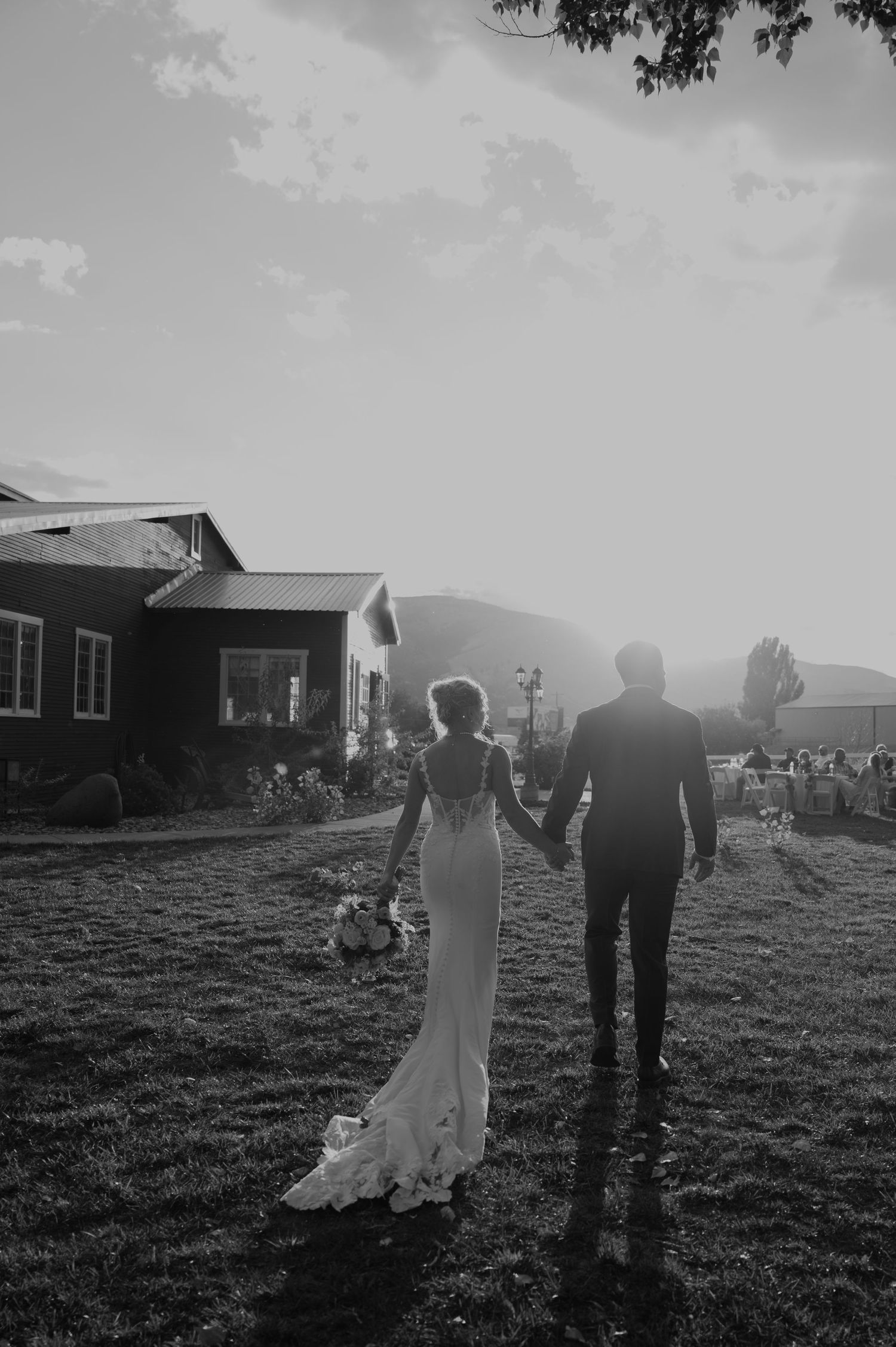 A black and white wedding portrait silhouetted against a rural landscape.
