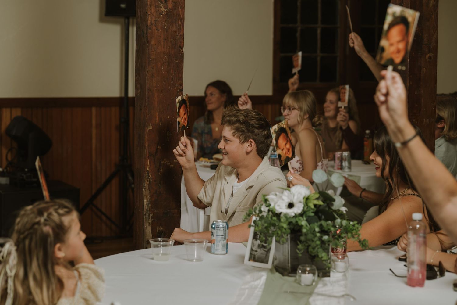 Wedding reception guests raising their hands in celebration during party festivities.
