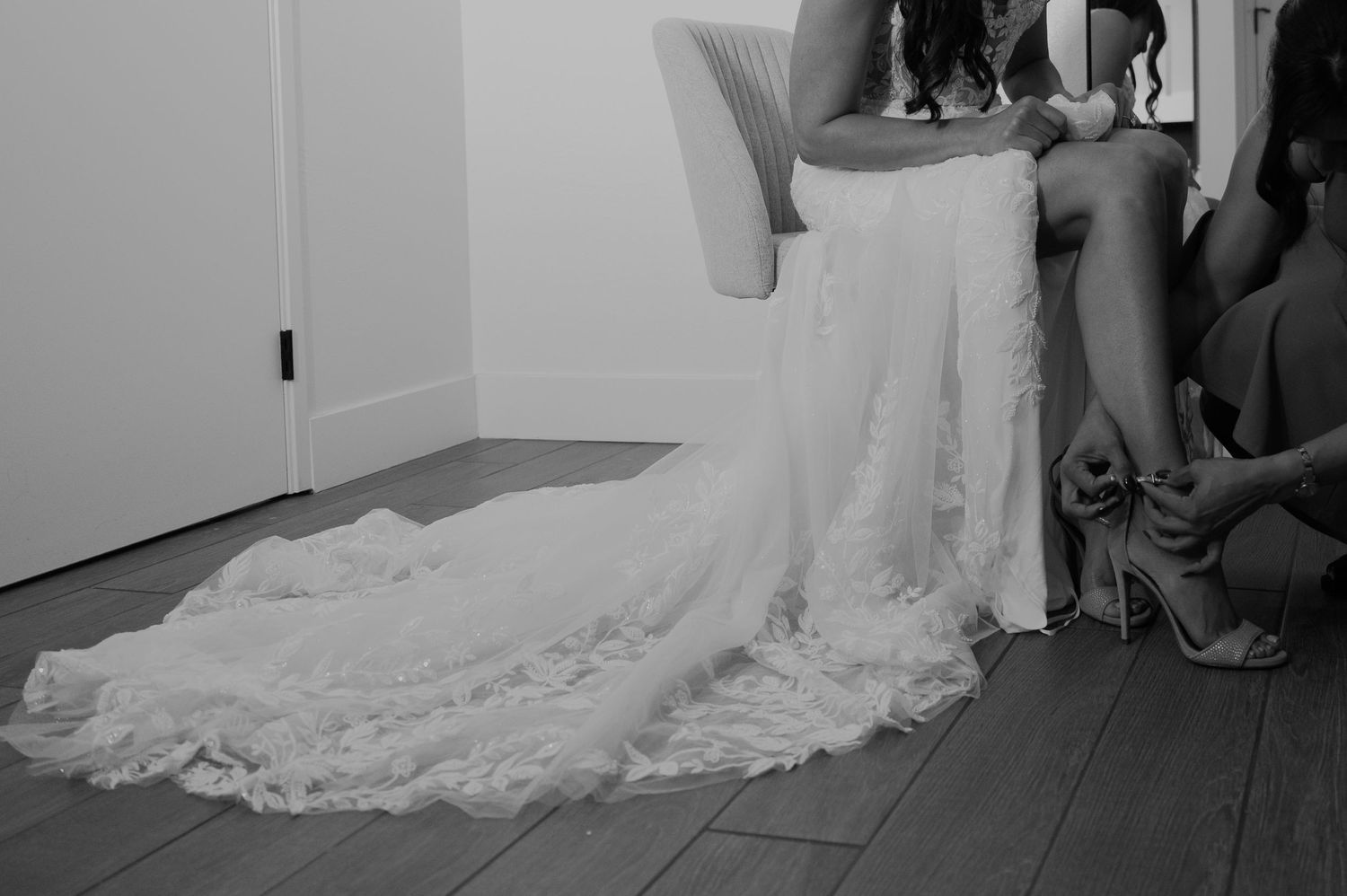 Black and white photograph showing the dramatic sweep of a wedding gown train.