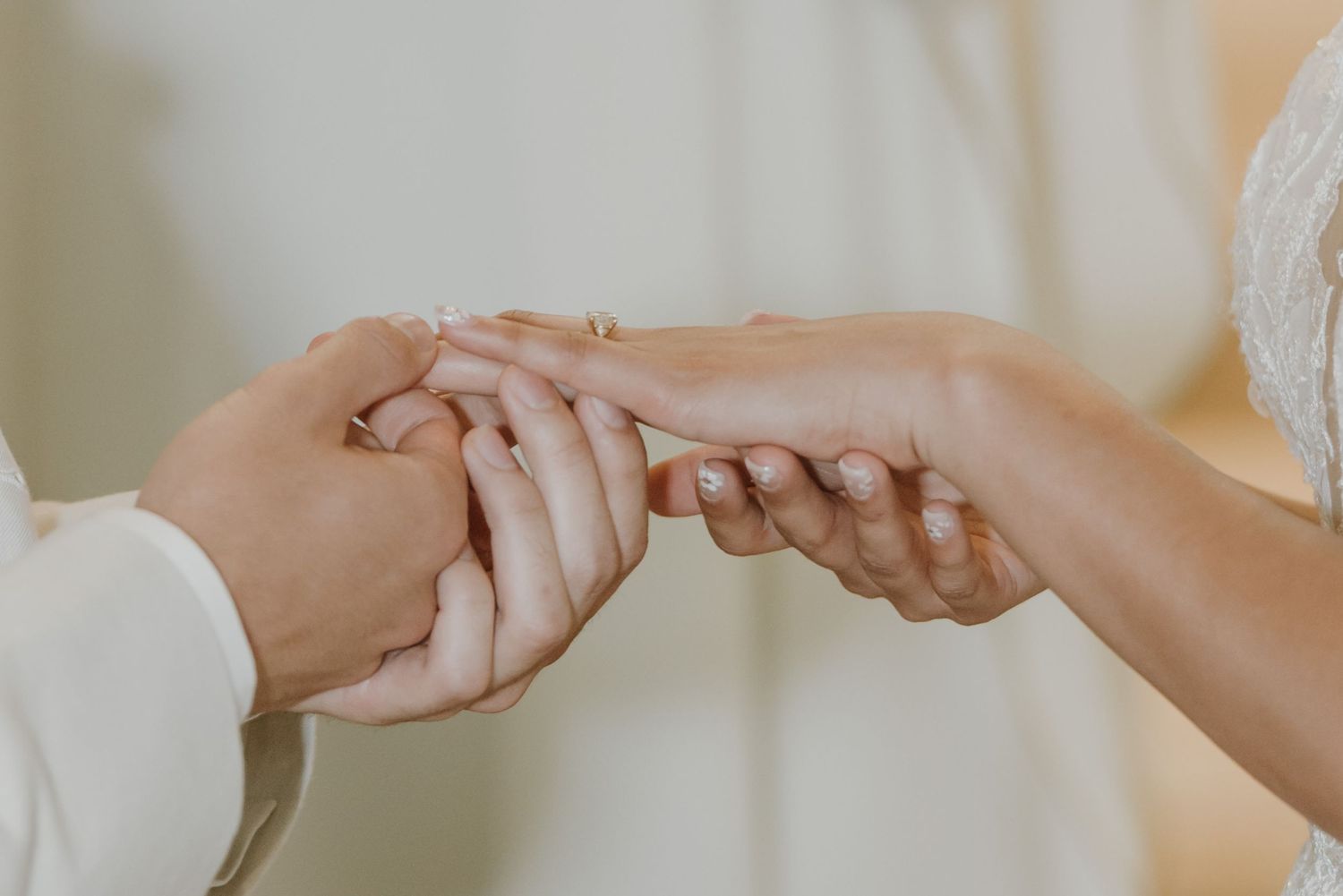 Close-up of bride and groom exchanging wedding rings during a romantic ceremony.