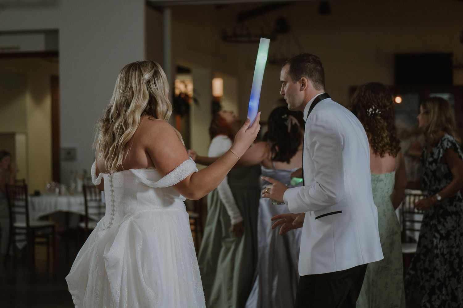 Bride and groom dancing with glow sticks at their wedding reception celebration.