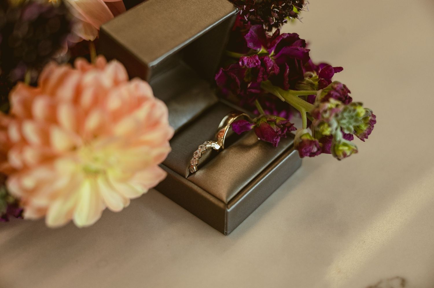 Delicate peach and purple flowers arranged artistically with wooden boxes.