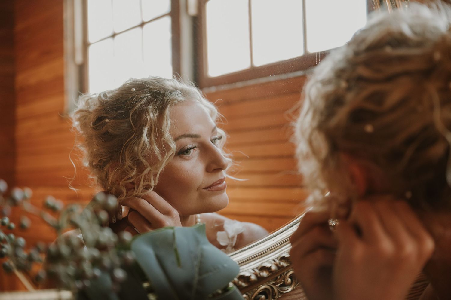 Warm sunlight streams through windows illuminating a bridal preparation scene.