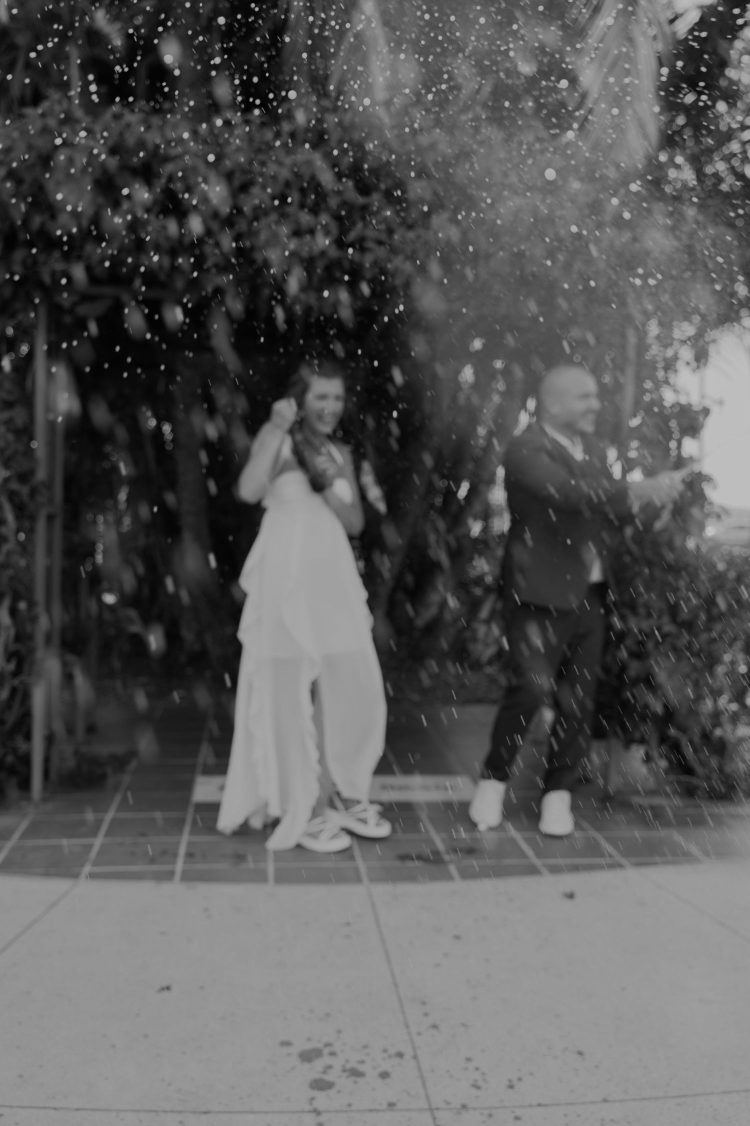 Silhouettes of two people sitting together as sparkles fall around them in the evening.