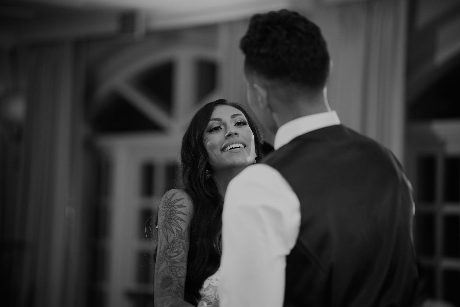 Guests share intimate dance moments during an indoor wedding celebration.