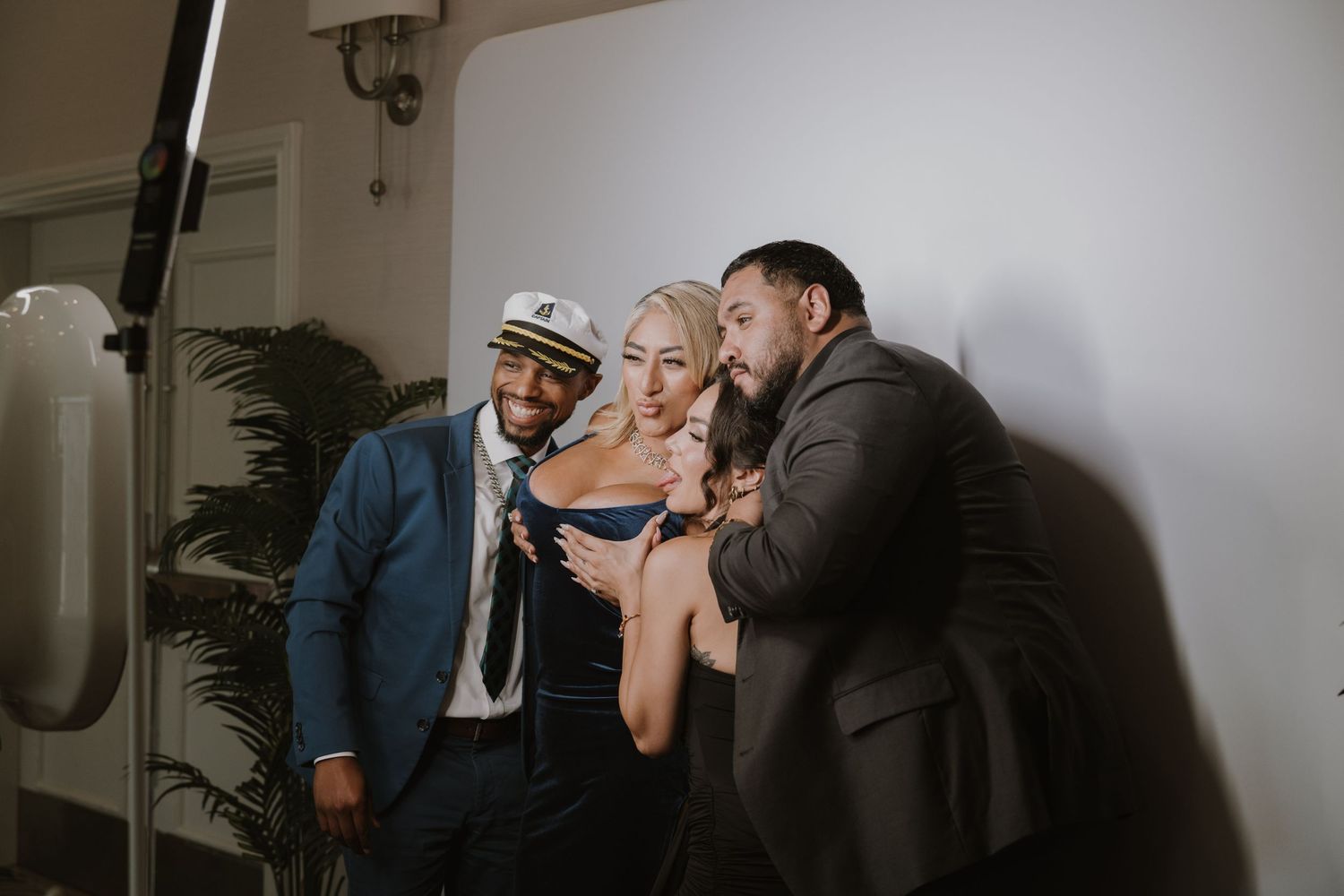 Wedding guests enjoying drinks and conversation in a dimly lit reception space.