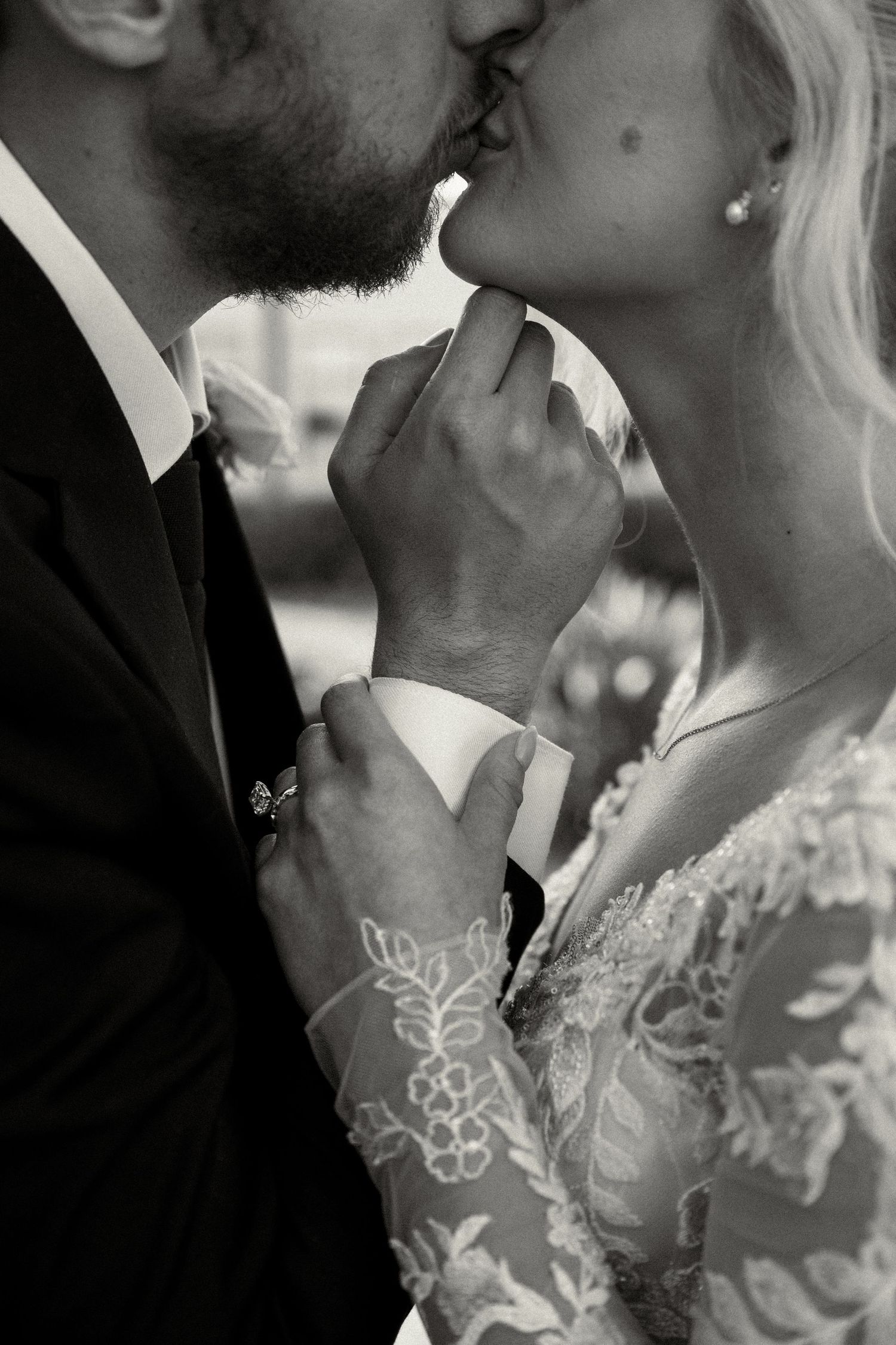 Black and white photo of bride and groom sharing romantic kiss on wedding day.