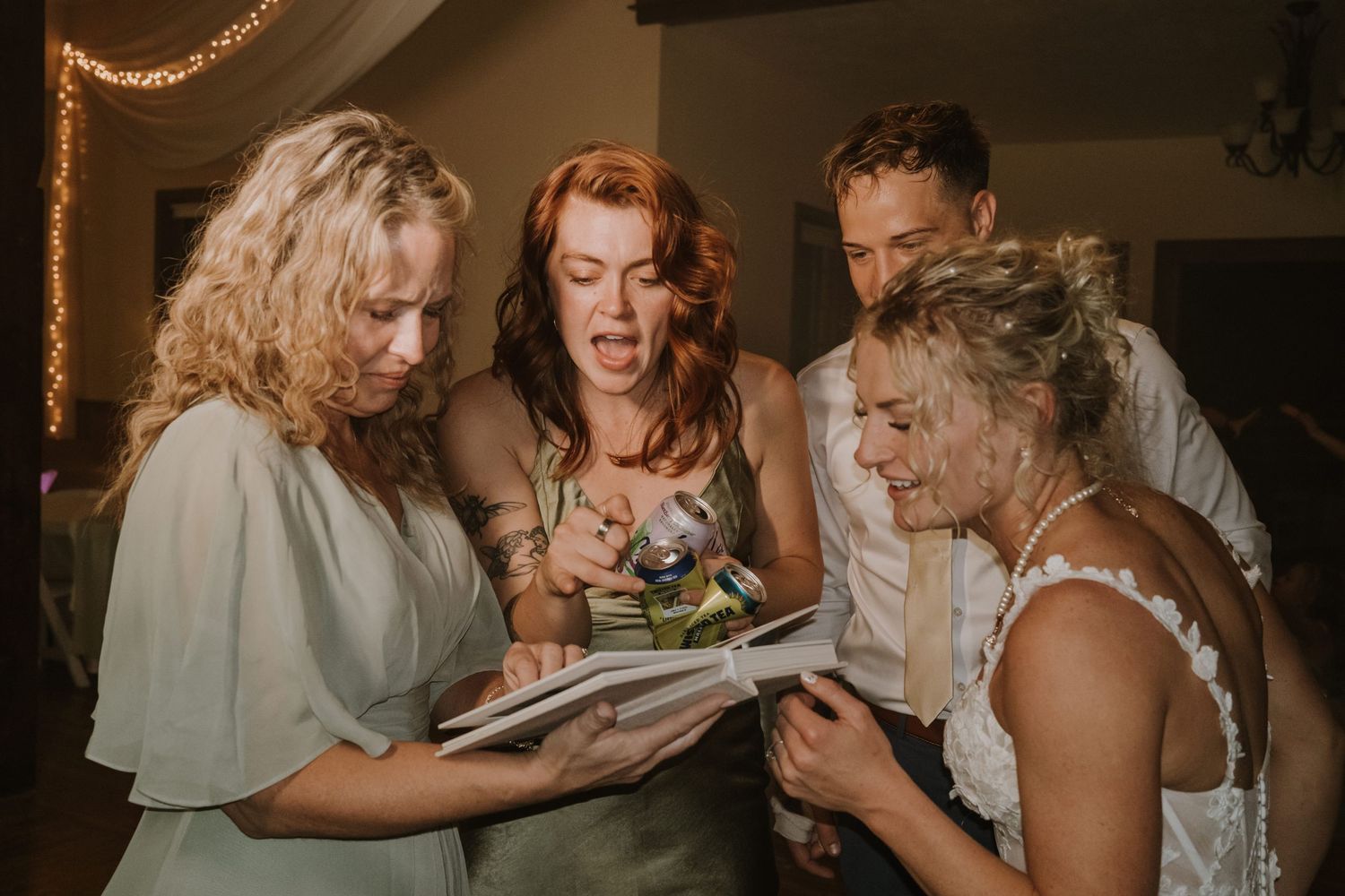 Wedding guests share an intimate moment while dancing at an indoor reception under warm lighting.
