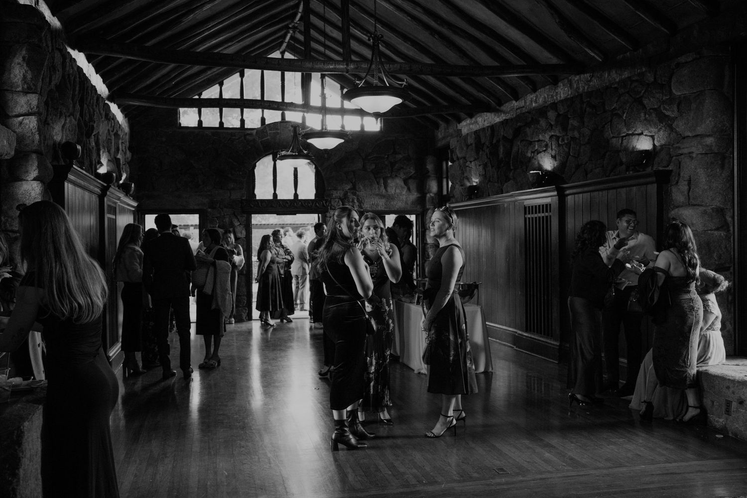 Dark atmospheric wedding venue interior with dramatic lighting and high beamed ceilings.