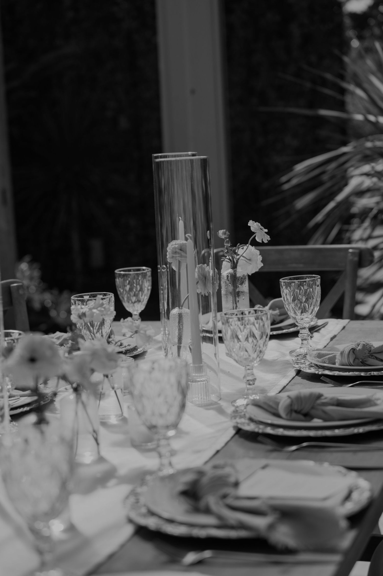 Elegant black and white wedding table setting with crystal glasses and floral centerpieces.