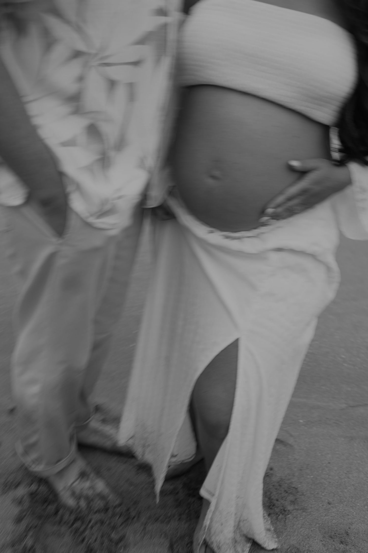 Black and white maternity photos showing flowing fabric and movement.