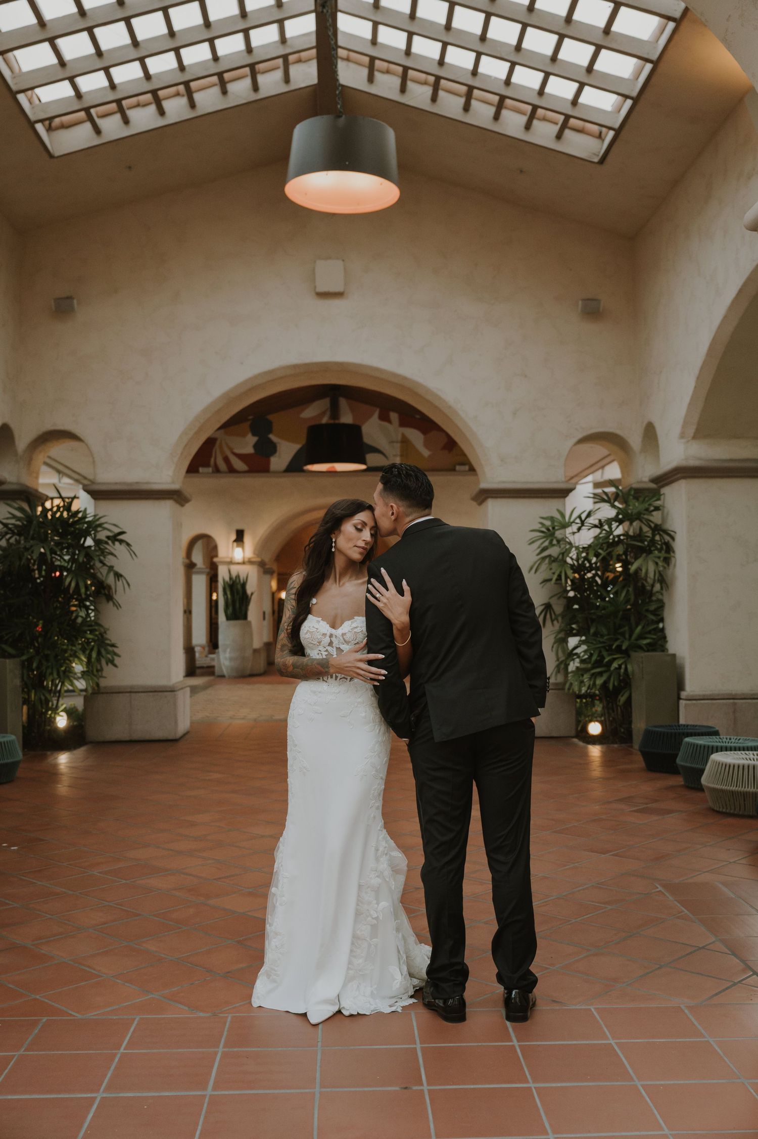 Couple shares an intimate dance moment in a Spanish-style indoor venue with terracotta floors.