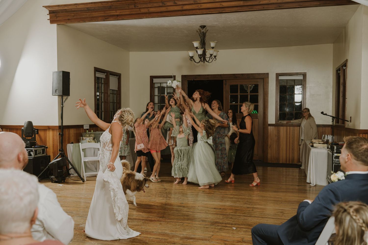 Wedding reception guests dancing and celebrating on a wooden dance floor.