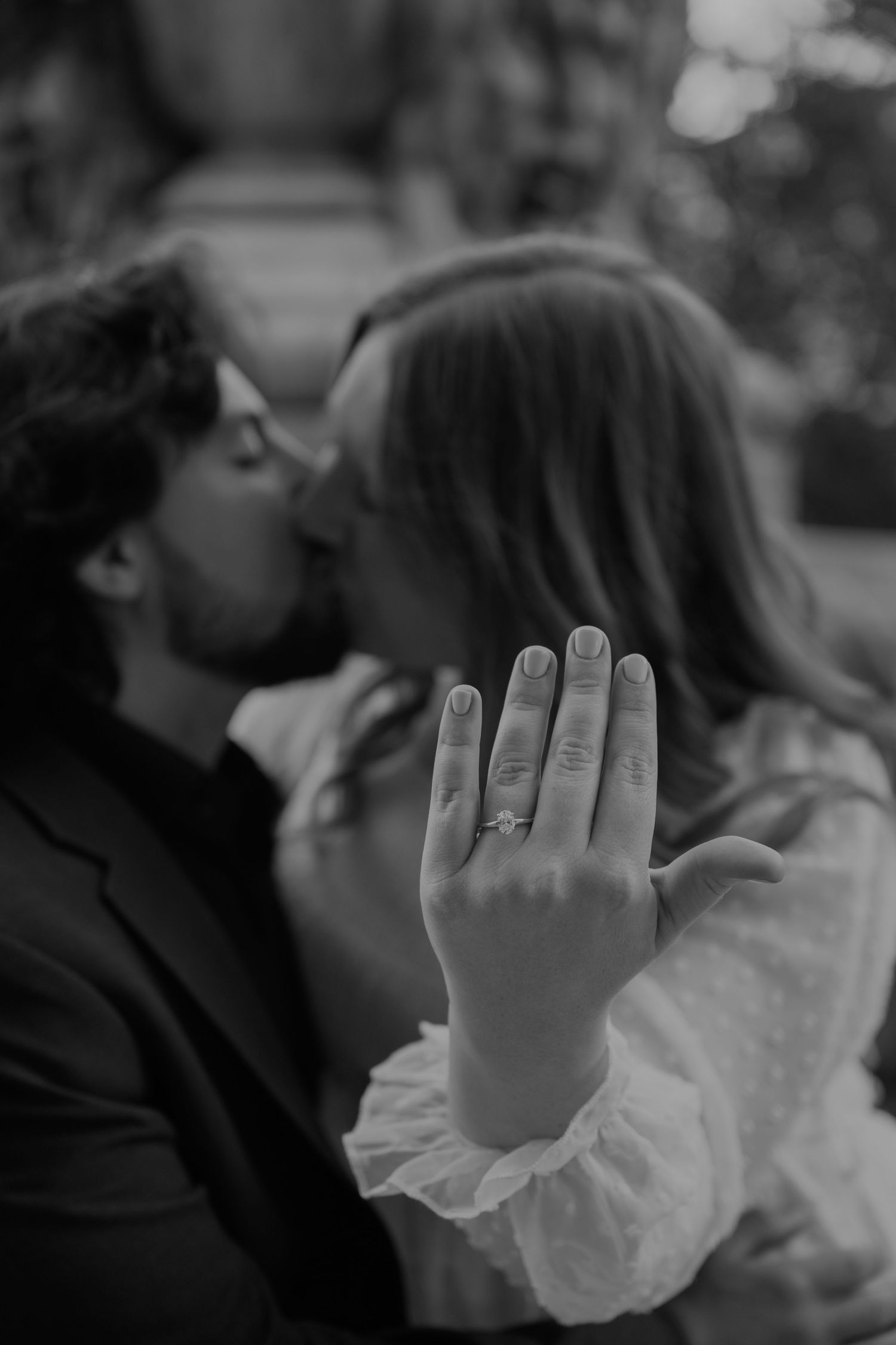 Black and white photo showing hands with lace sleeves and romantic embrace.