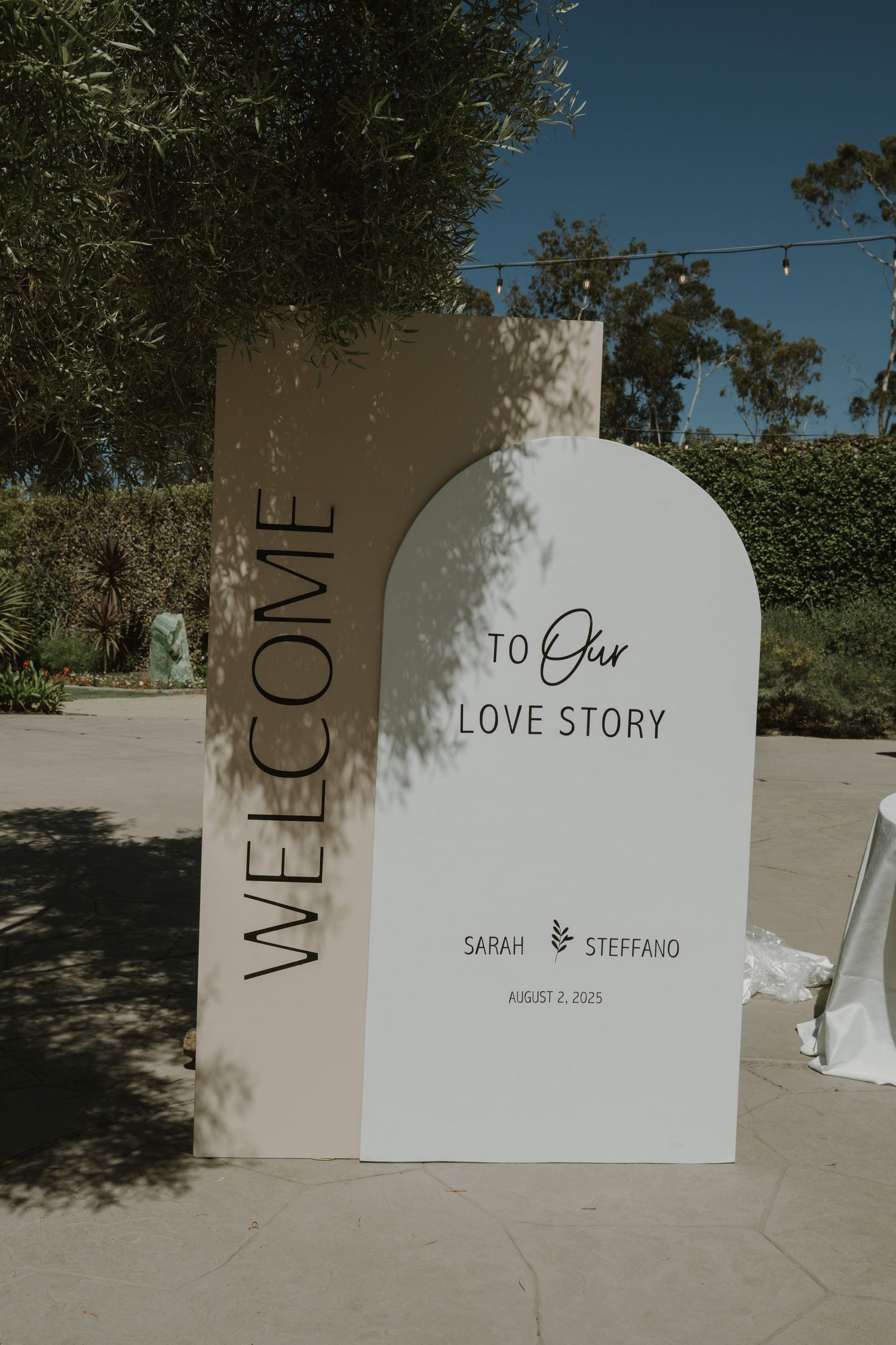 Elegant wedding welcome sign reading Welcome to Our Love Story for Sarah and Steffano, displayed outdoors.