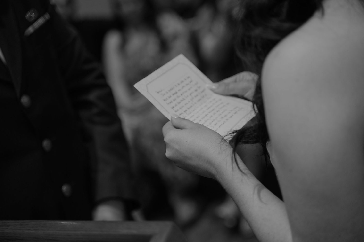 A close-up of hands holding wedding ceremony papers.