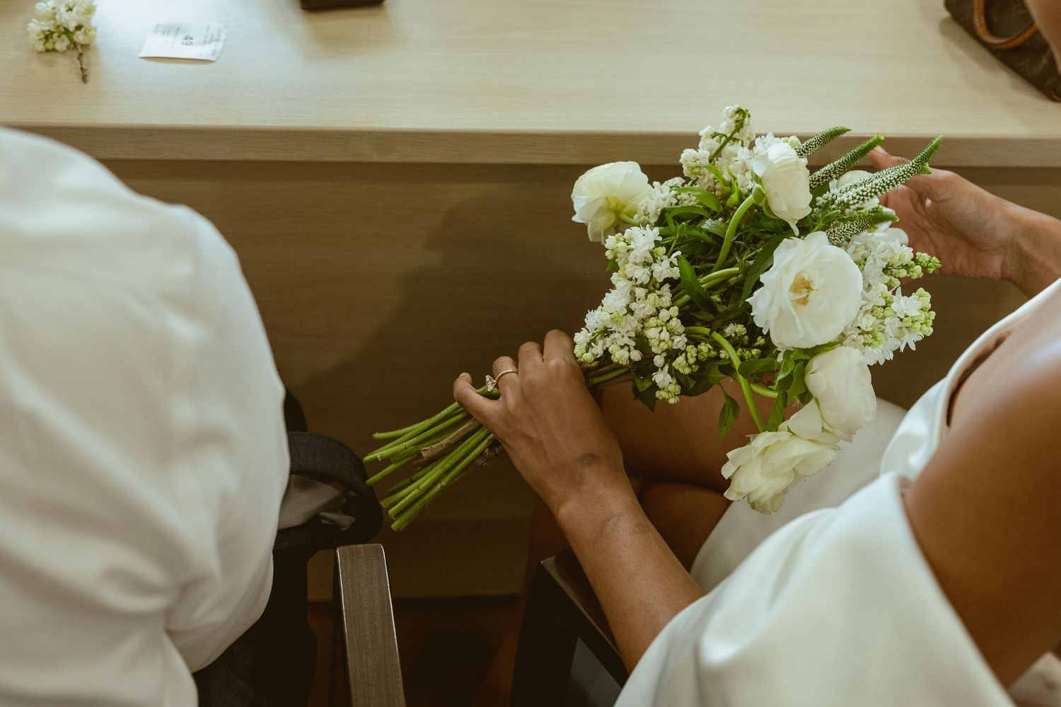 Close-up shots of white wedding bouquets with delicate flowers and greenery.