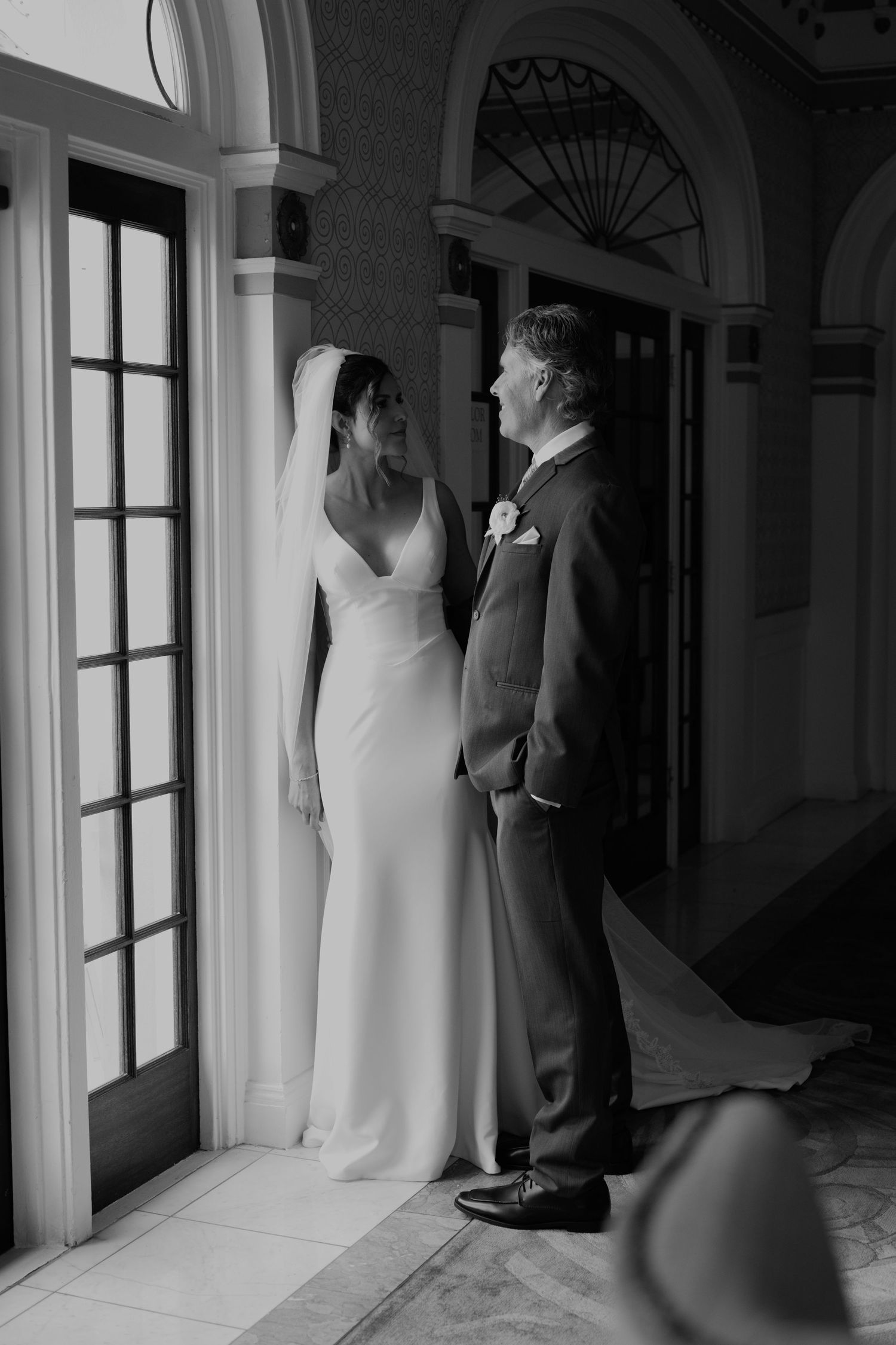 Elegant wedding photography in a historic building with grand windows and architectural details.