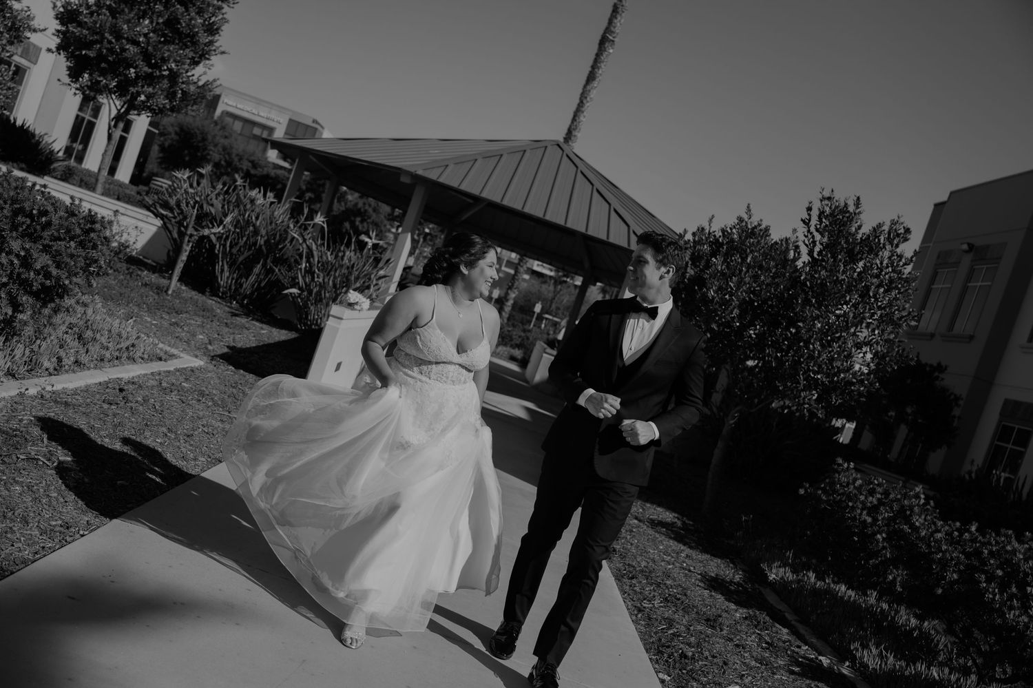 Black and white wedding photos arranged in a filmstrip style sequence showing outdoor moments.