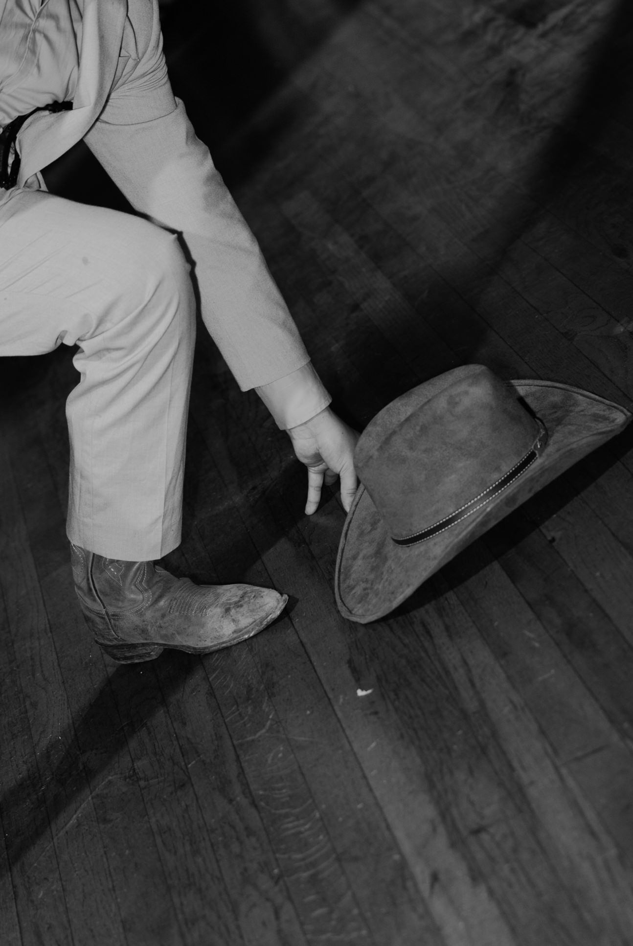 Close-up view of dancing feet moving across a dark wooden floor.
