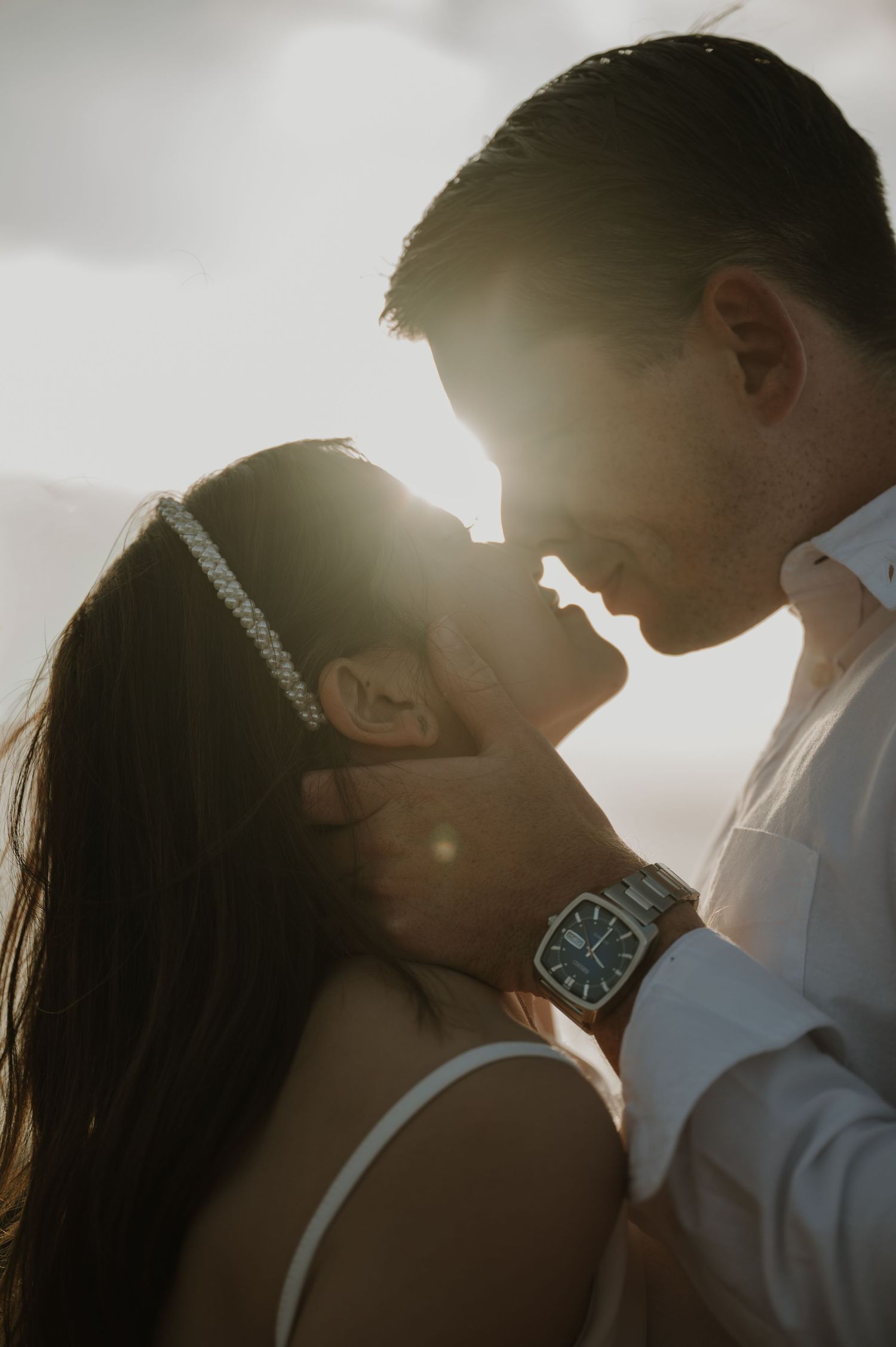 Romantic silhouette of couple against golden sunlight.