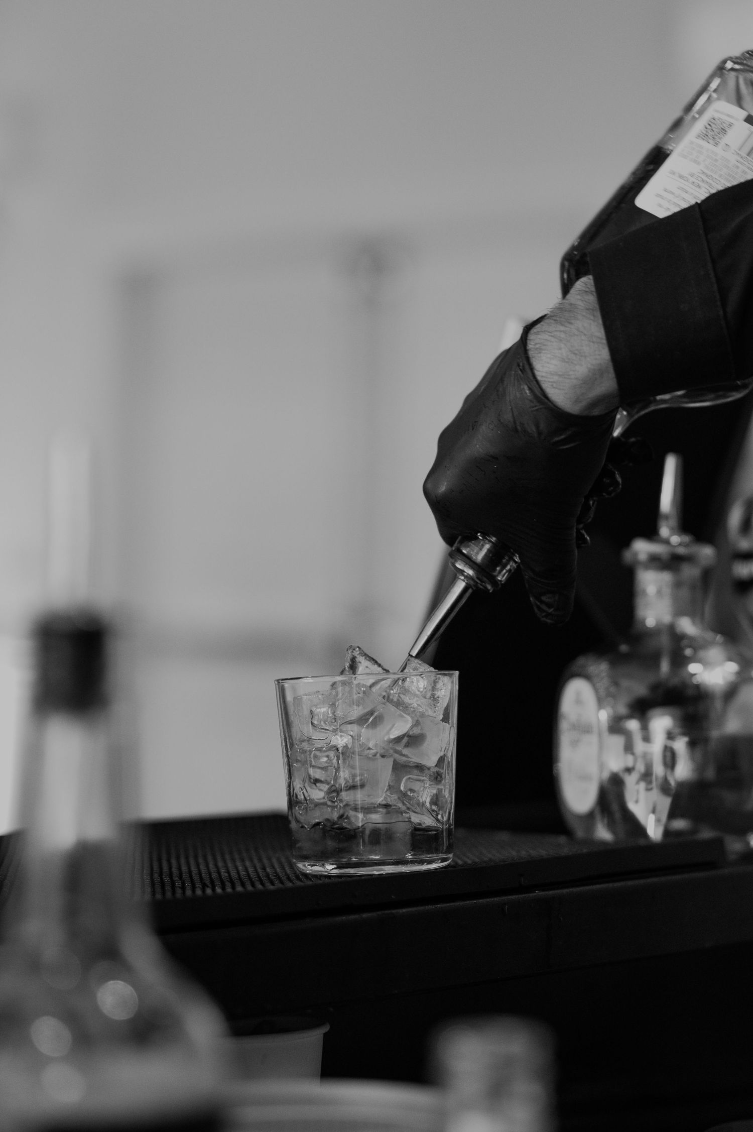 Bartender preparing craft cocktails at an elegant wedding reception bar.
