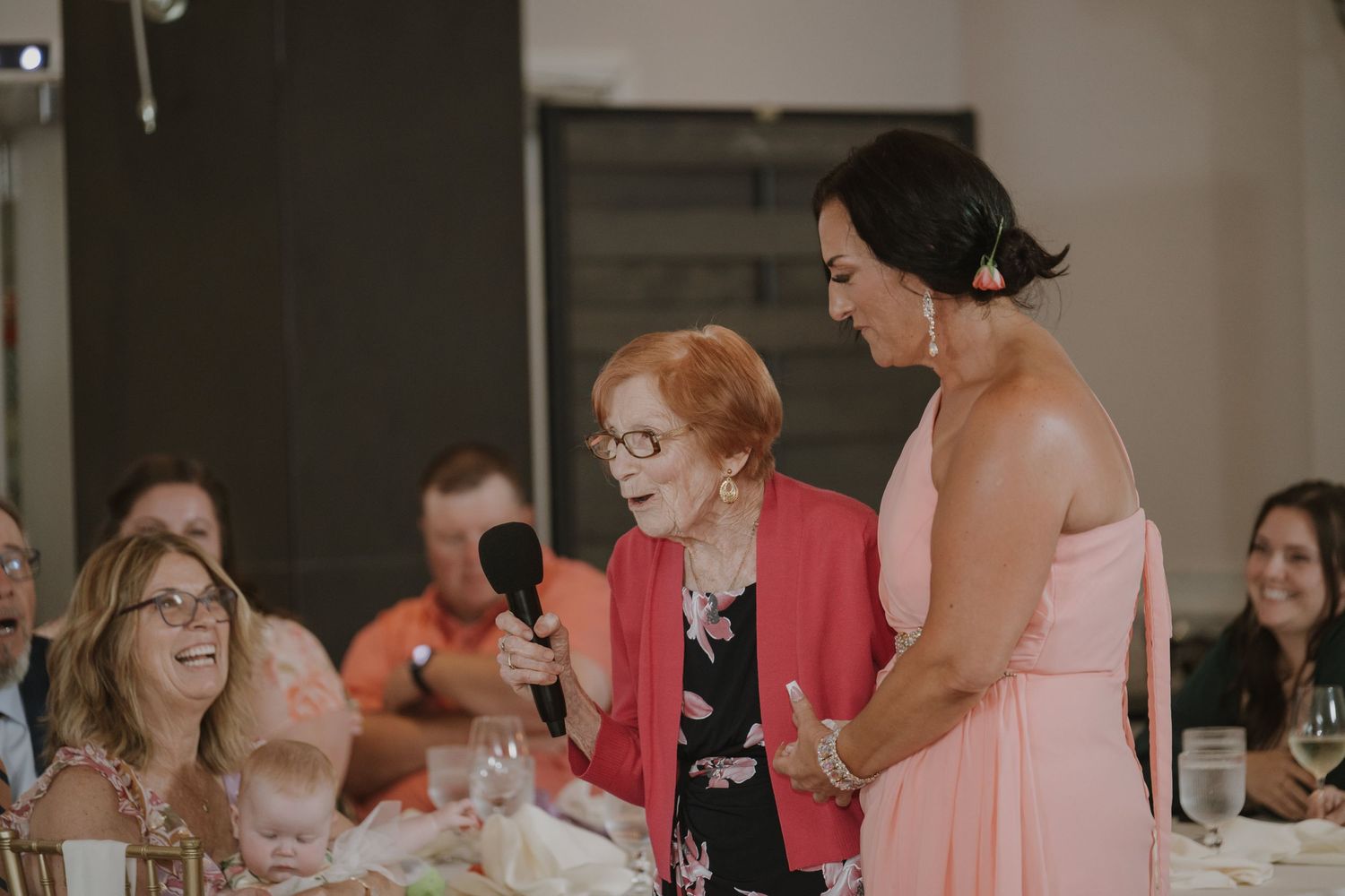 Wedding reception guests enjoying a lively conversation at decorated tables.