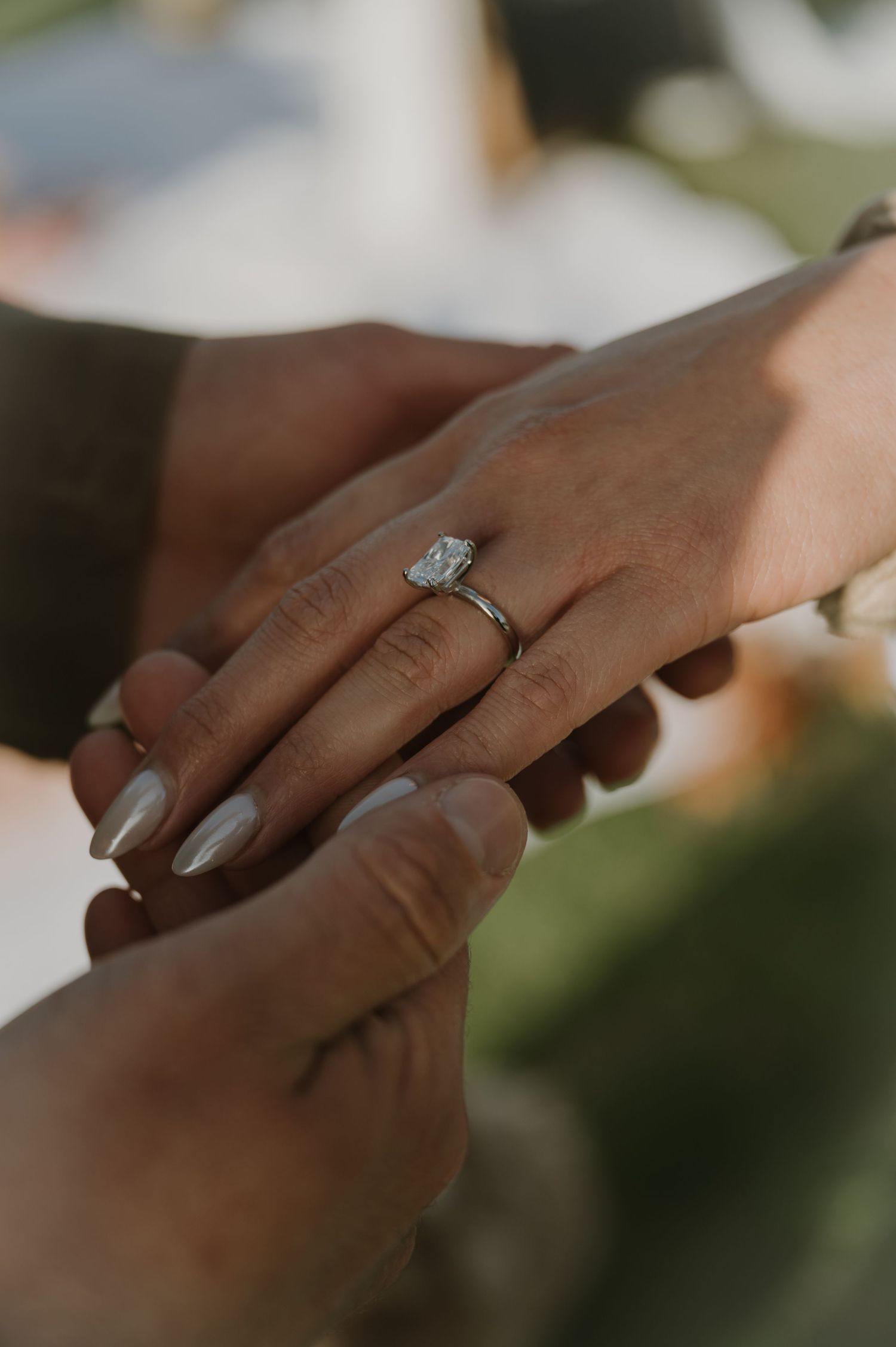 Close-up shots of hands with engagement rings showing tender moments of touch.