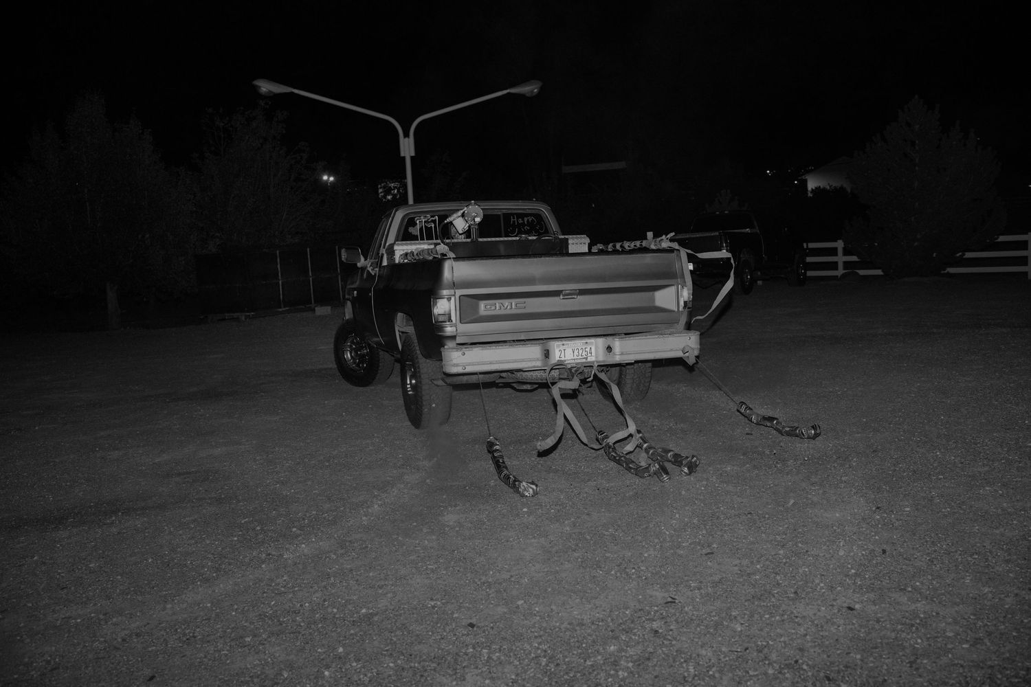 Vintage vehicles parked in a dark field during nighttime wedding celebrations.