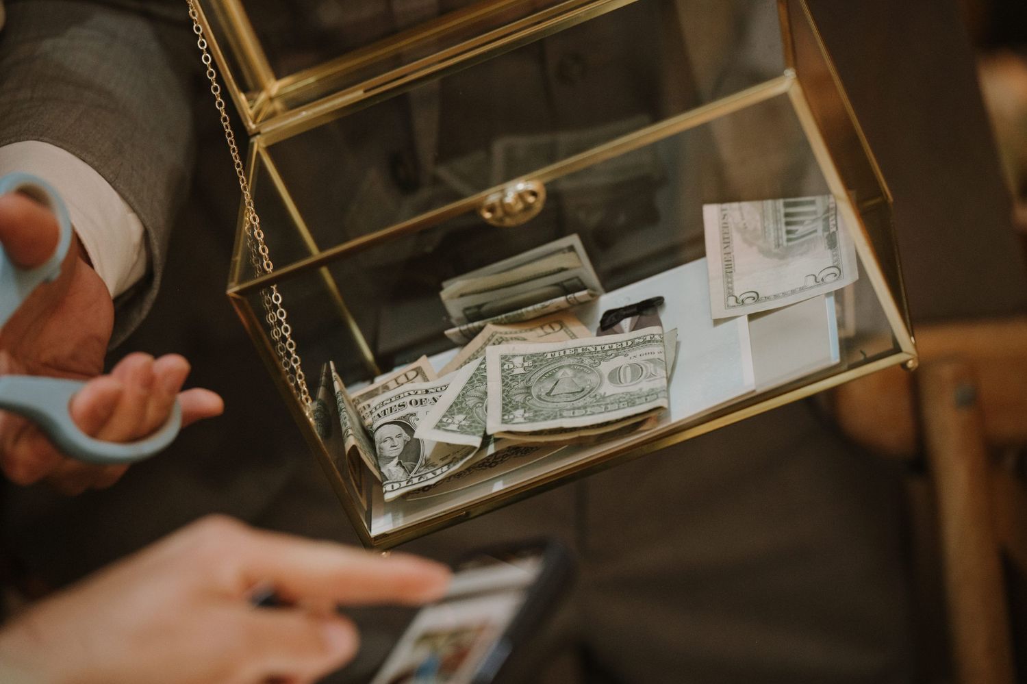 Glass box filled with cash money gifts at a wedding reception celebration.
