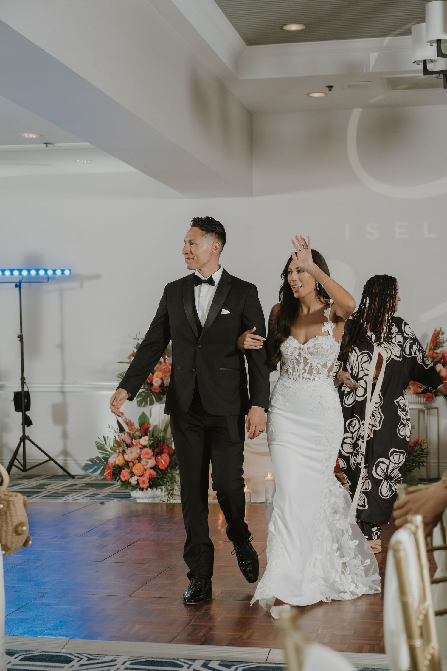 Newlyweds dancing and celebrating on wooden floor during wedding reception.