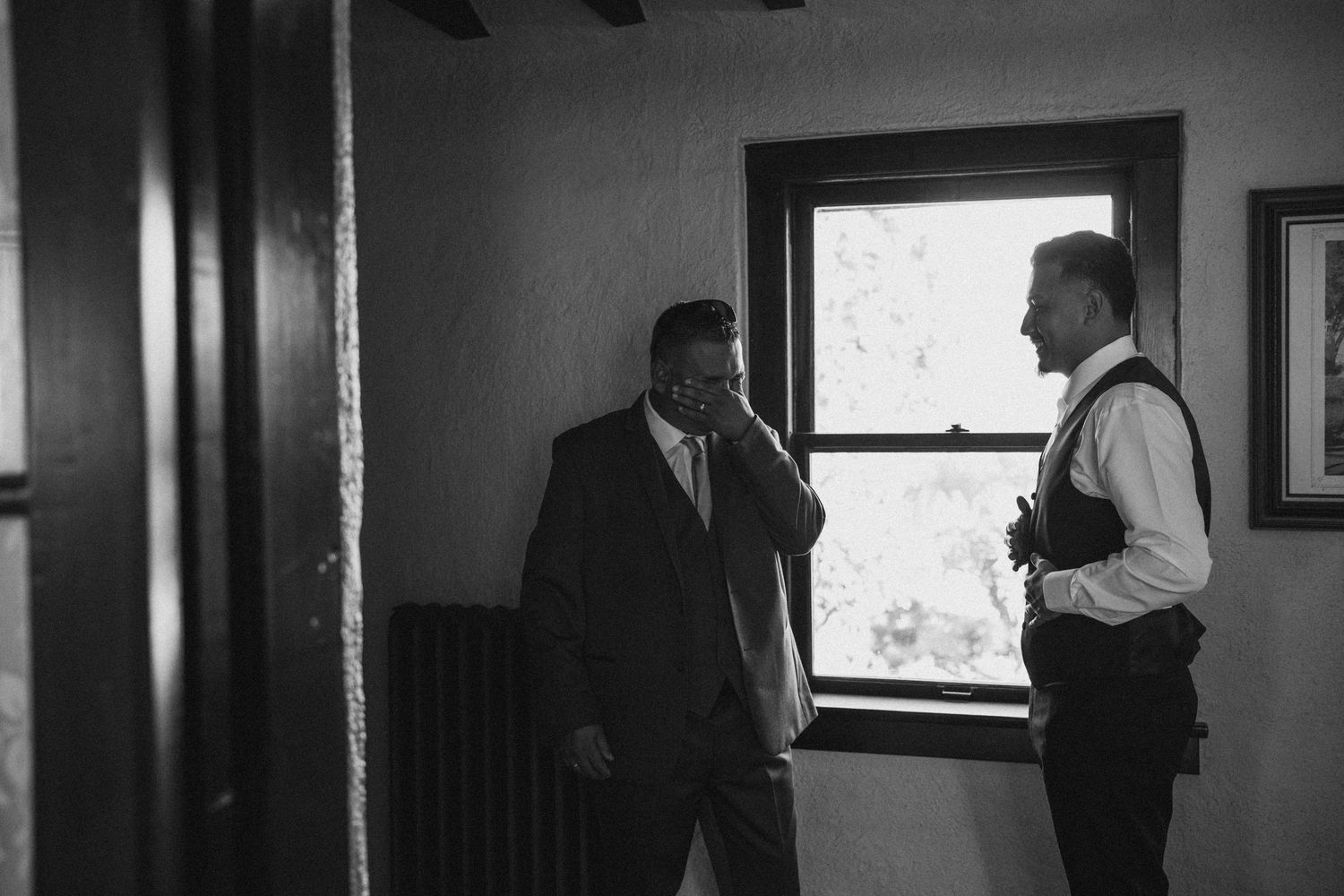 Black and white photo of formal preparation in a window-lit room.