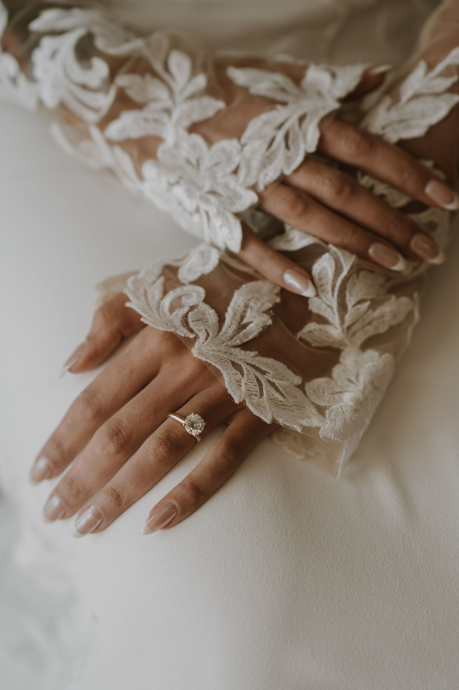 Delicate lace details on bridal gloves shown in an intimate close-up photograph.