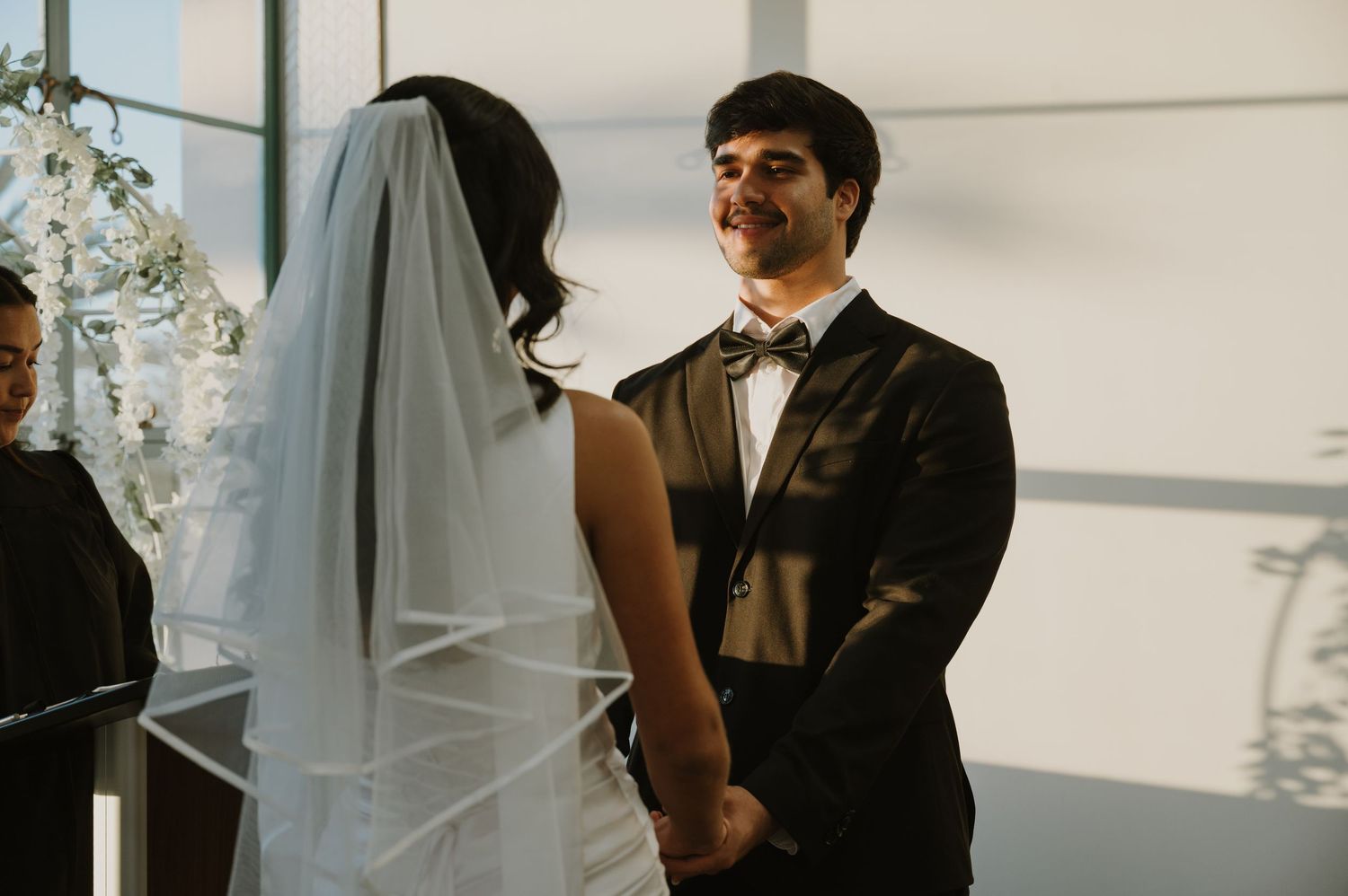 Wedding couple shares intimate moments in a bright indoor setting with natural lighting.