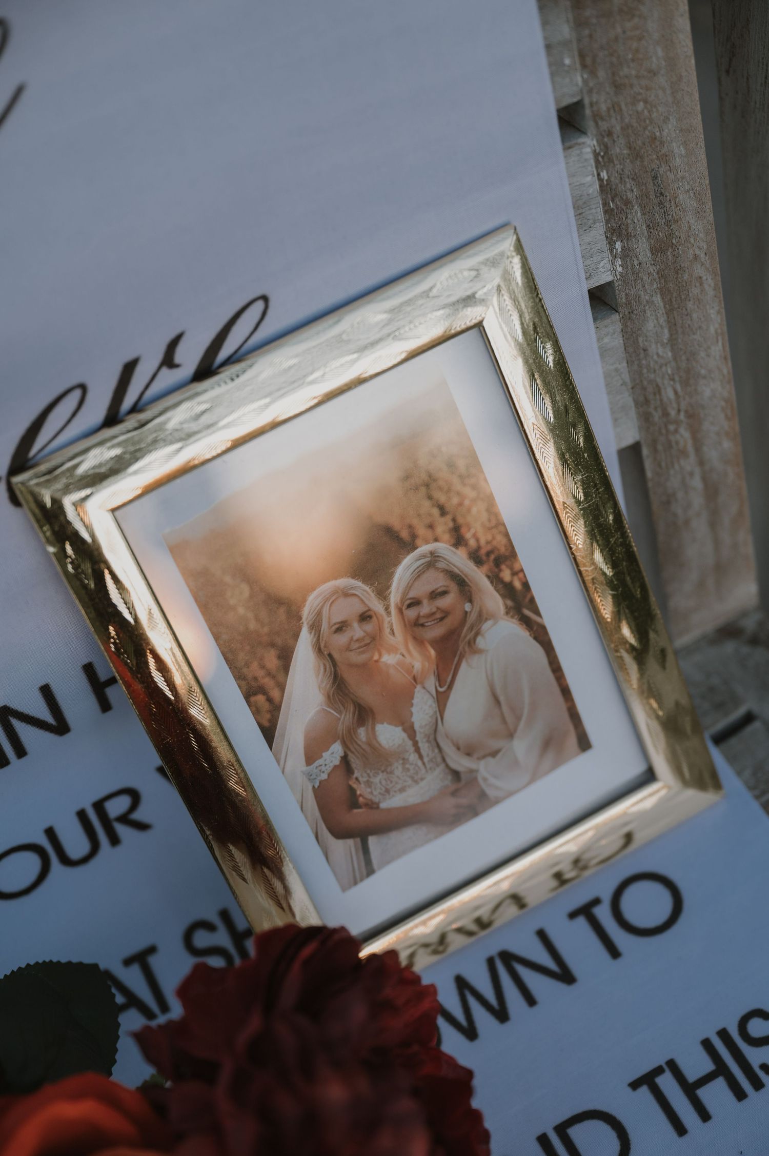 Framed photograph displayed with red roses in moody lighting.