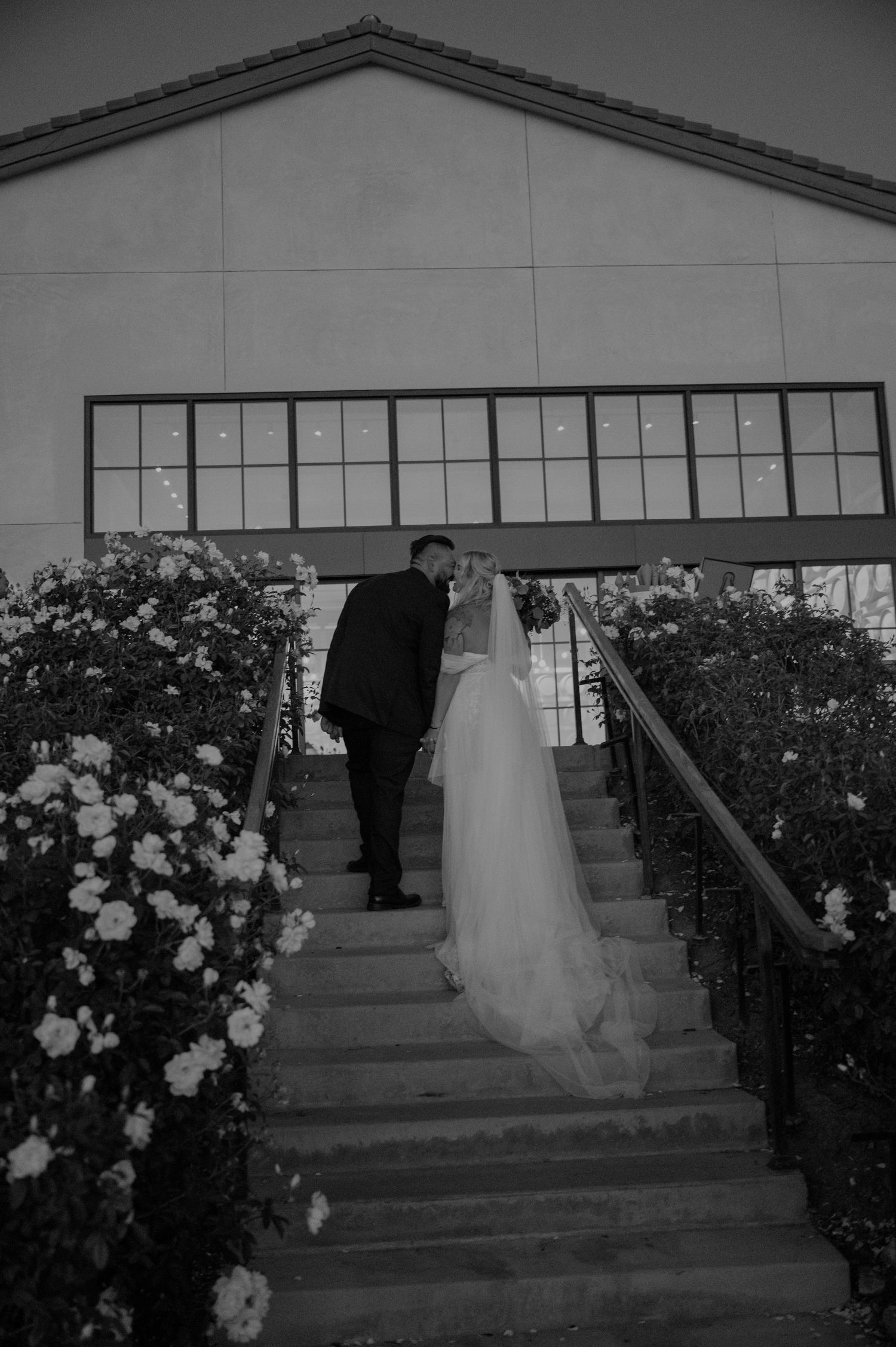 Black and white wedding ceremony photos on church steps lined with white roses.