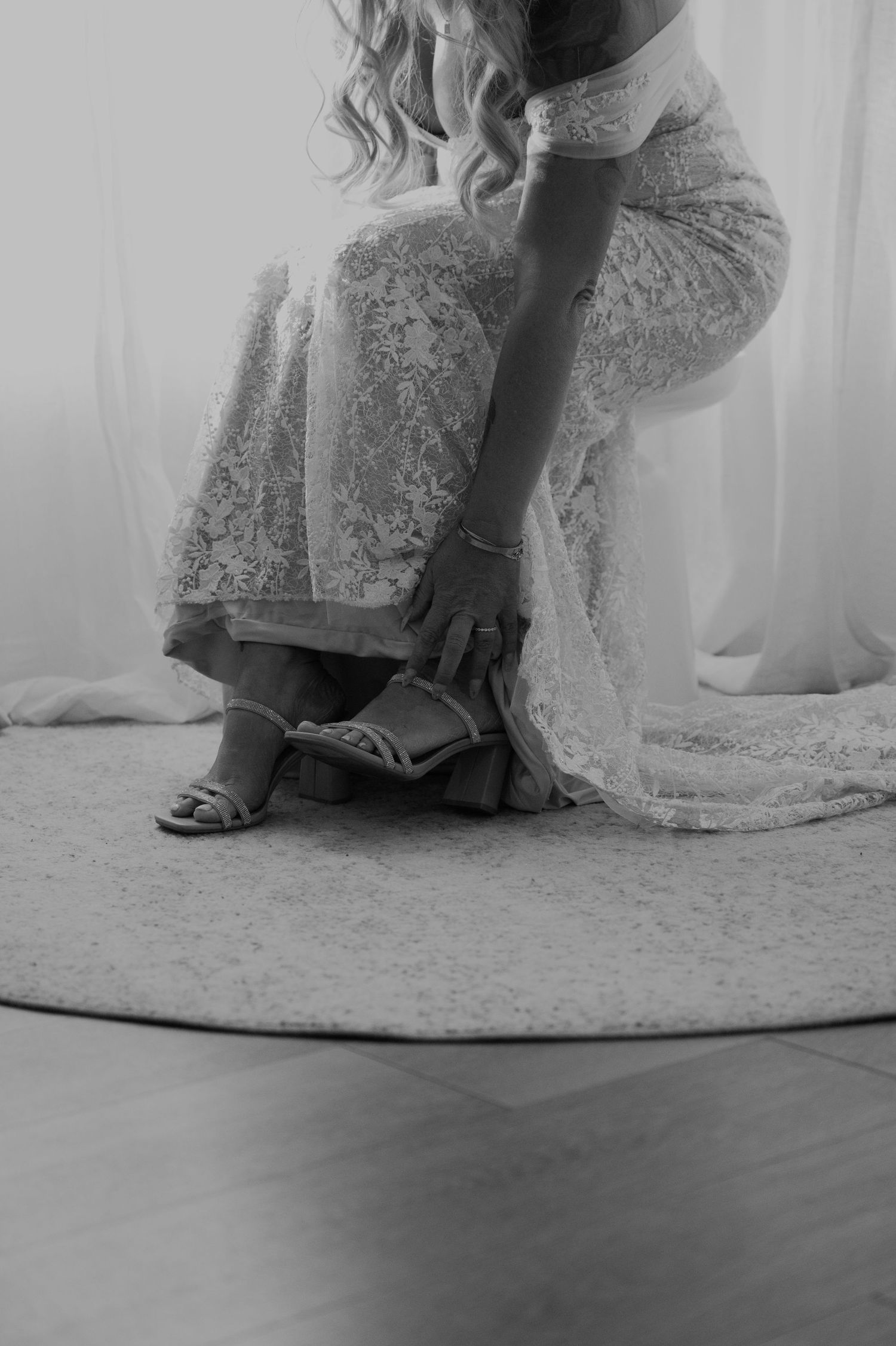 Black and white image of bridal details focusing on dress hem and shoes.
