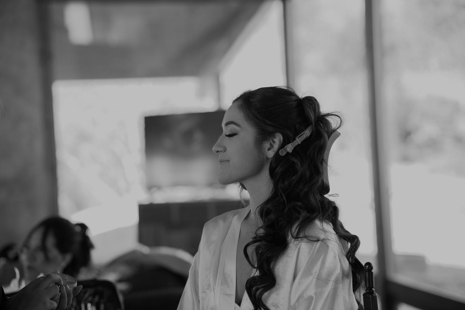 Black and white profile shot of person with elegant curled hairstyle.