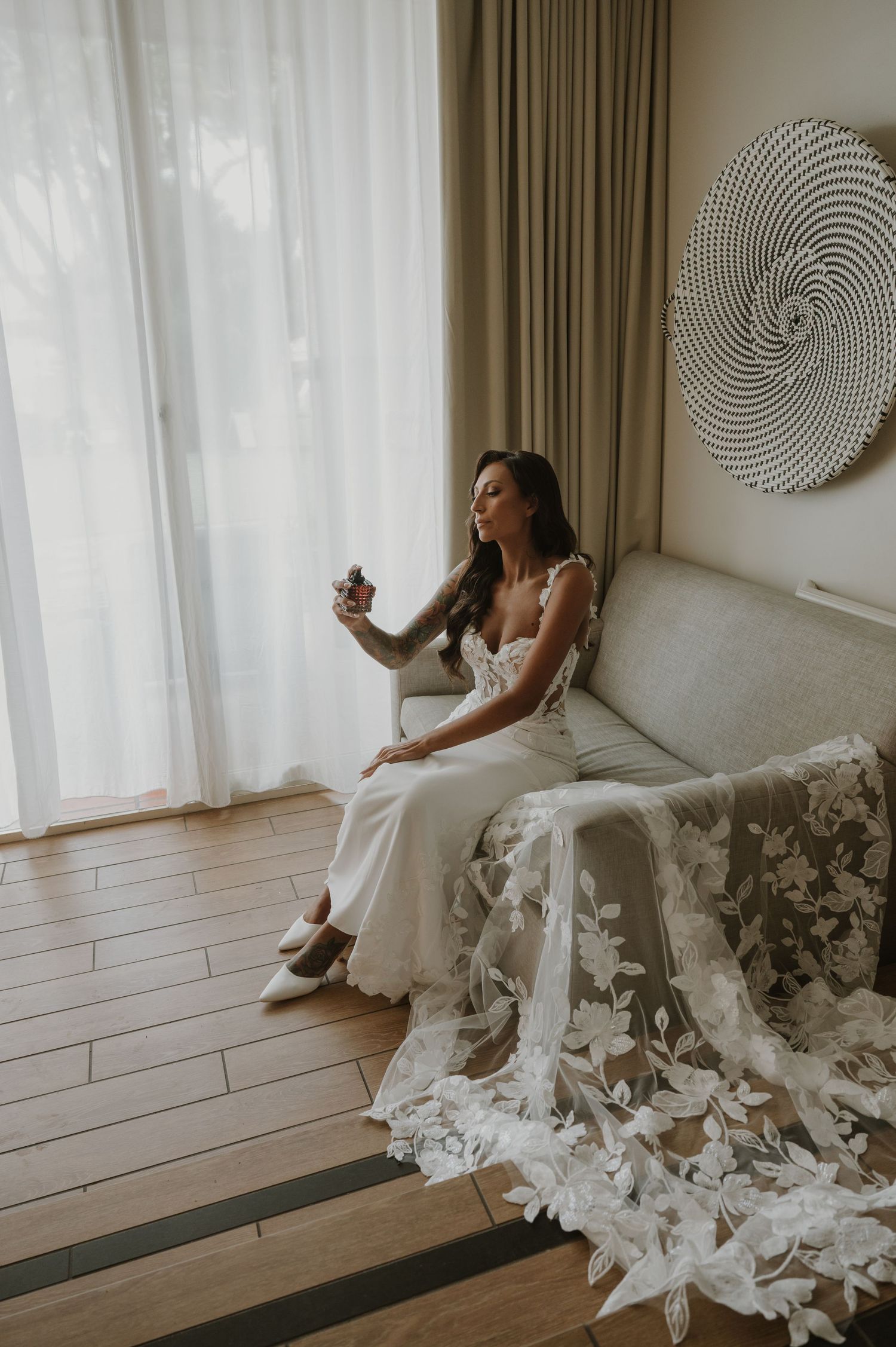 A bride in an elegant white lace gown poses by a window in a series of artistic shots.