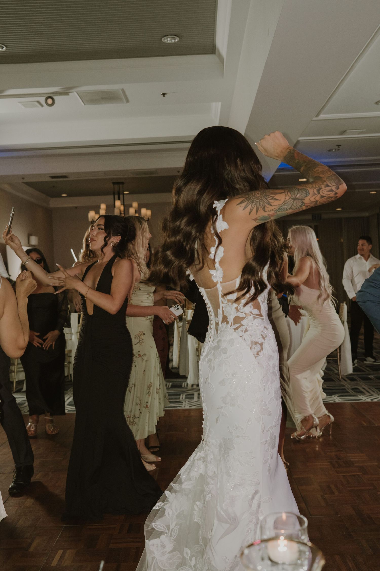 Wedding party dancing and having fun during an indoor reception celebration.