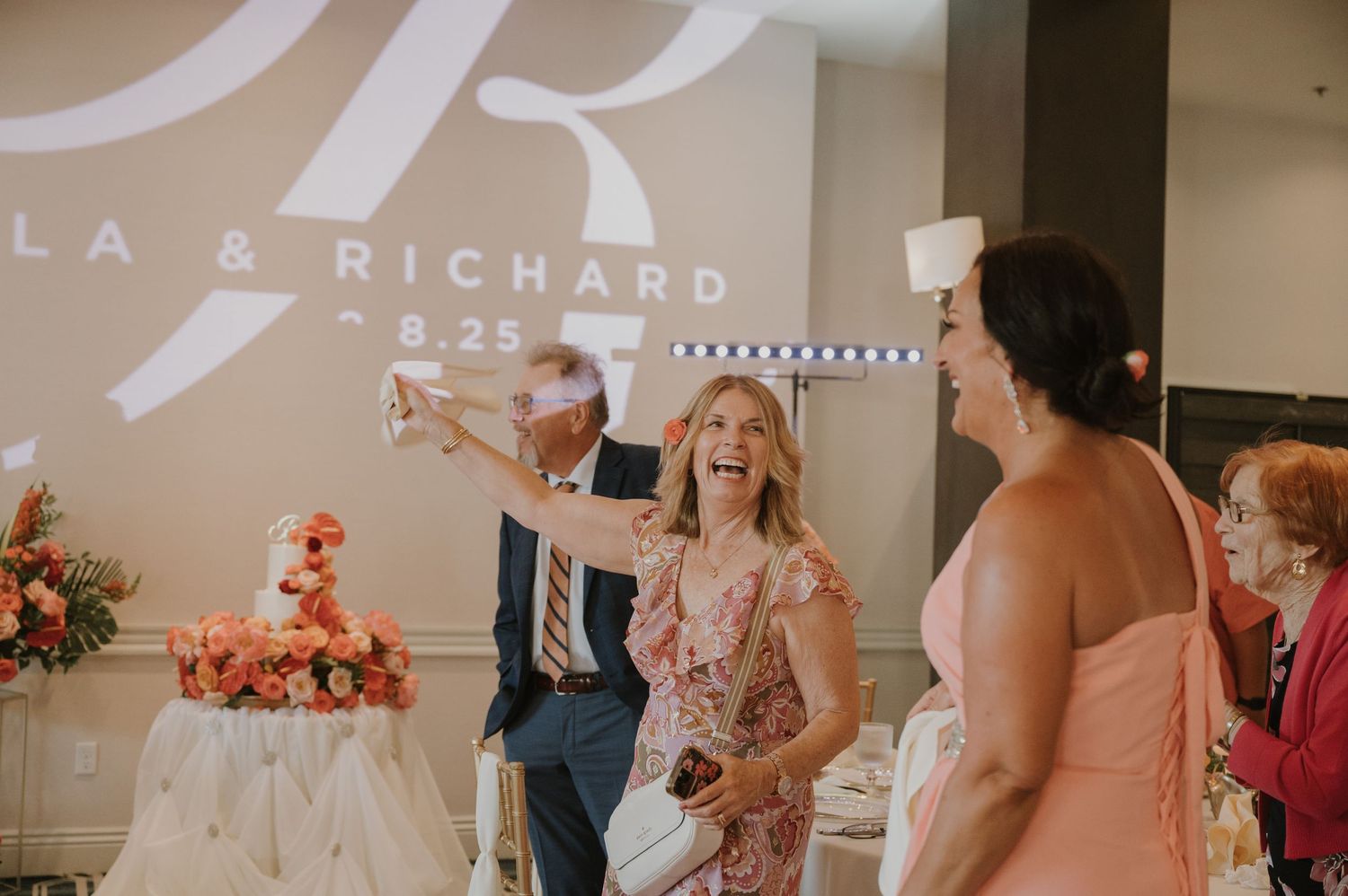 Wedding celebration with guests dancing and enjoying festivities under decorative lighting.