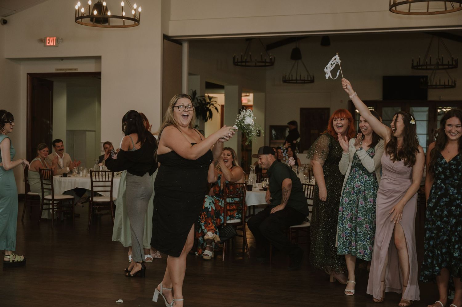 Wedding guests dancing and celebrating on the dance floor during a lively wedding reception party.