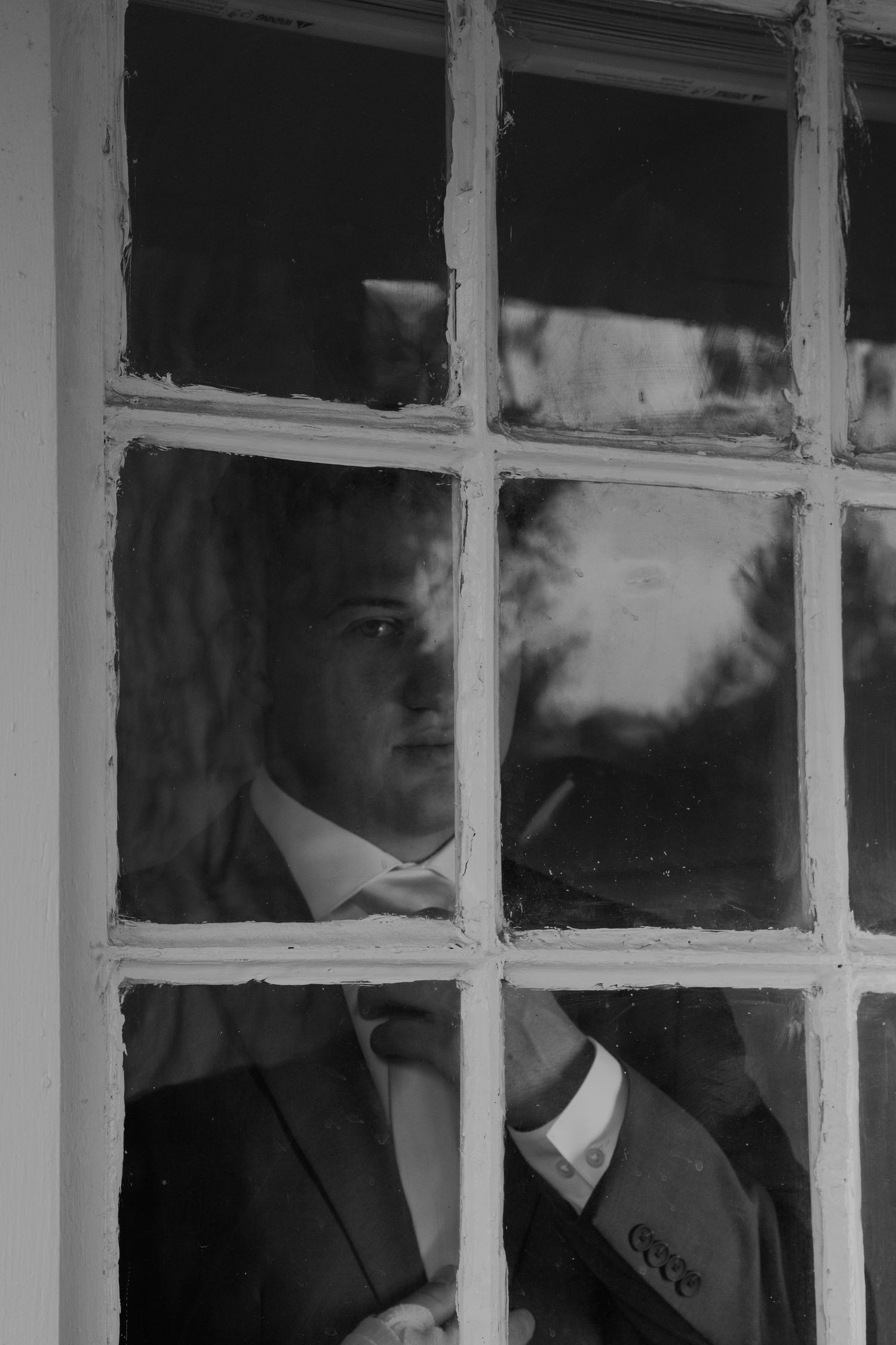 Dramatic window-framed portrait with geometric shadows and light.