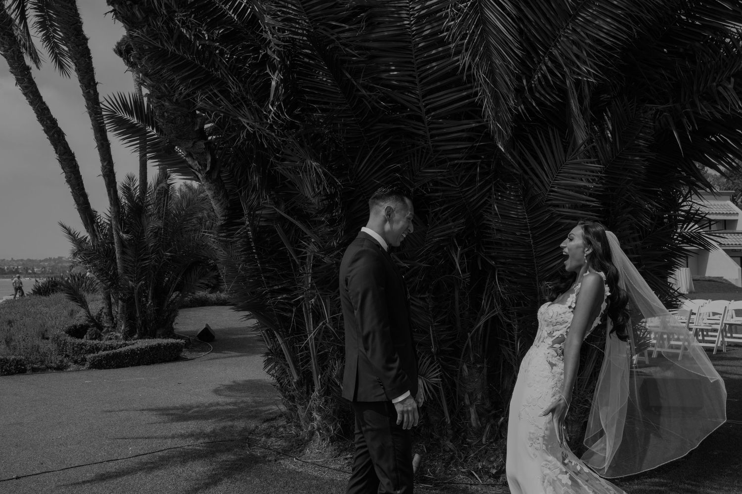Artistic black and white photo of hands signing wedding documents.