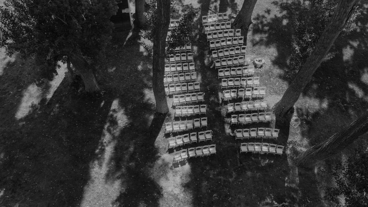 Aerial view of wedding ceremony seating arranged in a grassy outdoor venue.