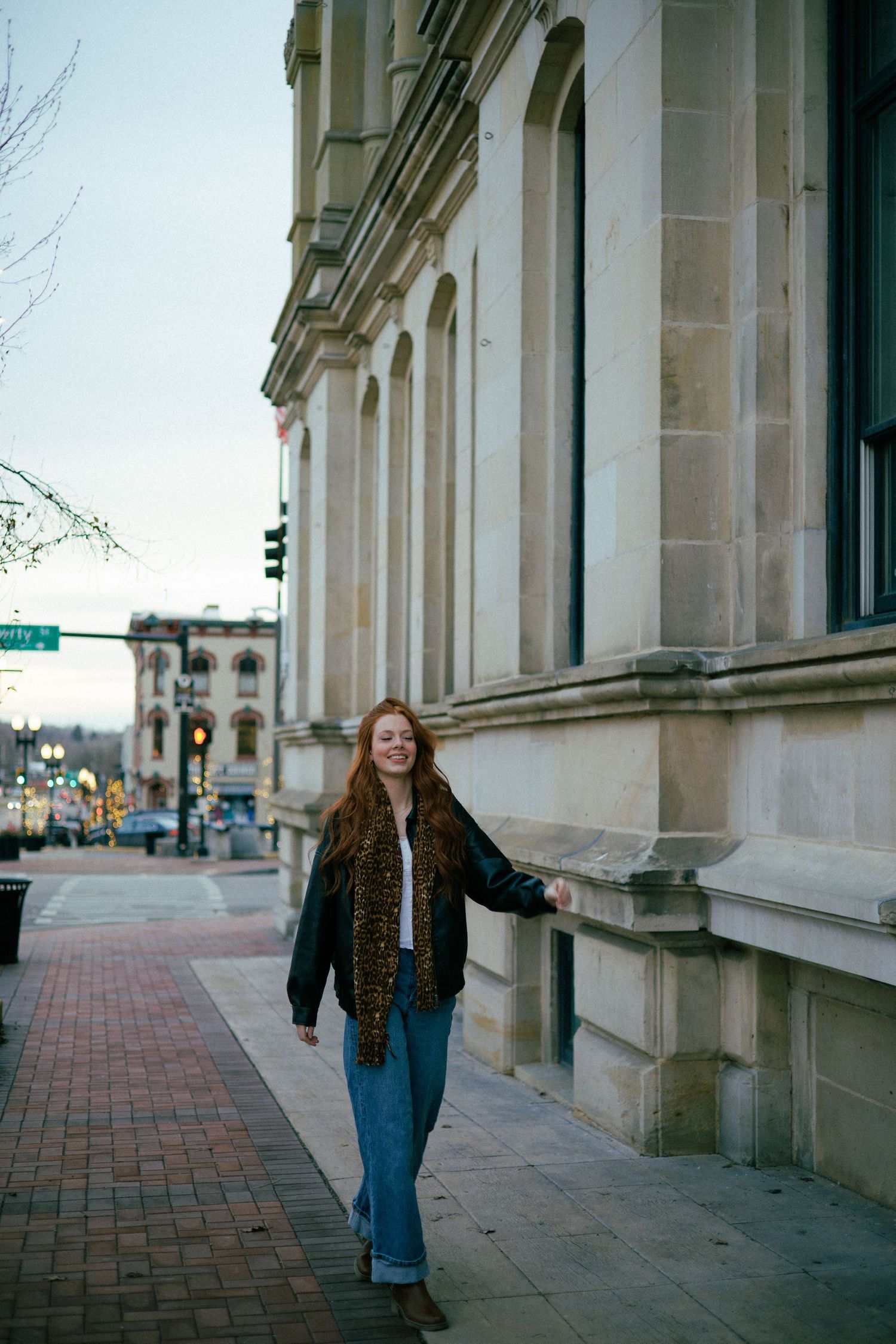 Street style photography along historic building with brick sidewalk and classical architecture.