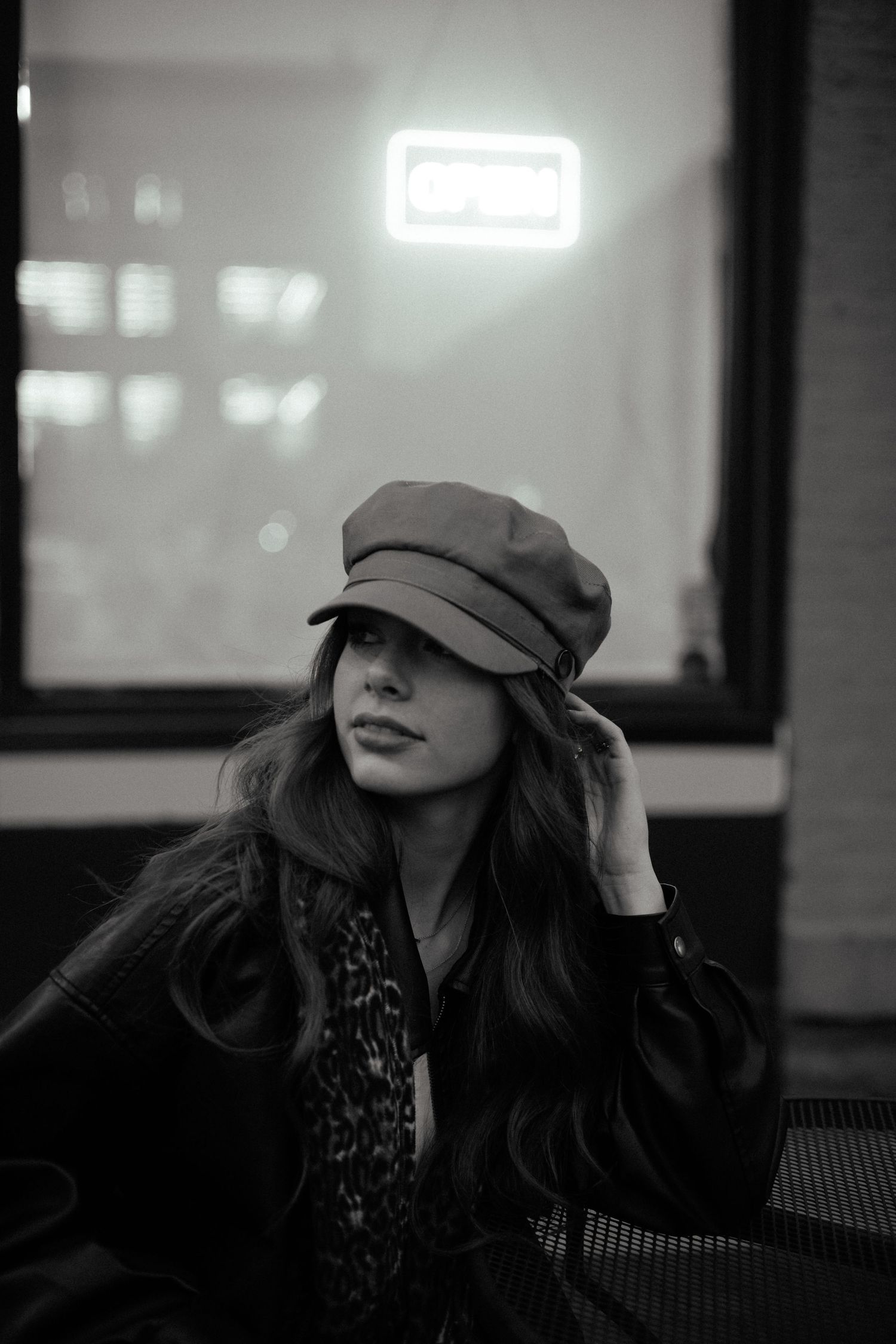 Moody black and white portraits of someone wearing a cap in dramatic lighting.